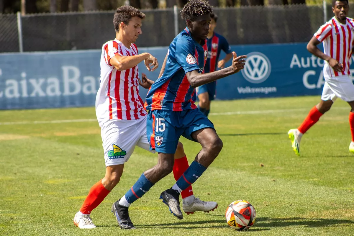 Javito, jugador del Barbastro, encima a otro del Huesca B, este miércoles en la Base Aragonesa. Foto: SDH