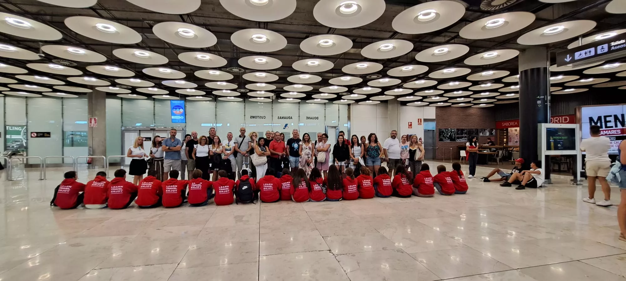 Imagen de alumnos y familias en el aeropuerto en Madrid, con estudiantes de Barbastro.