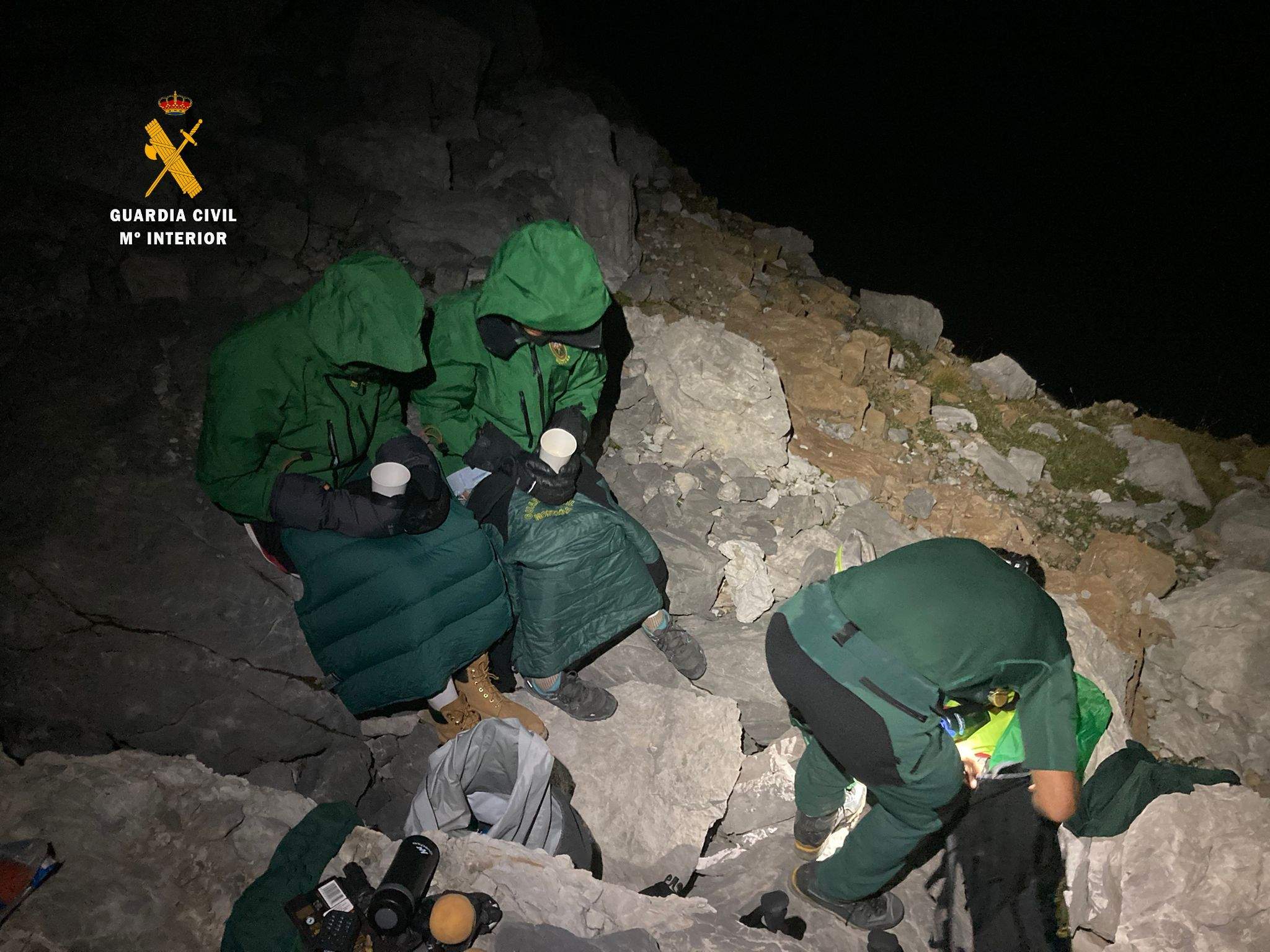 Los montañeros con la ropa de los especialistas y una bebida caliente Los montañeros con la ropa de los especialistas y una bebida caliente