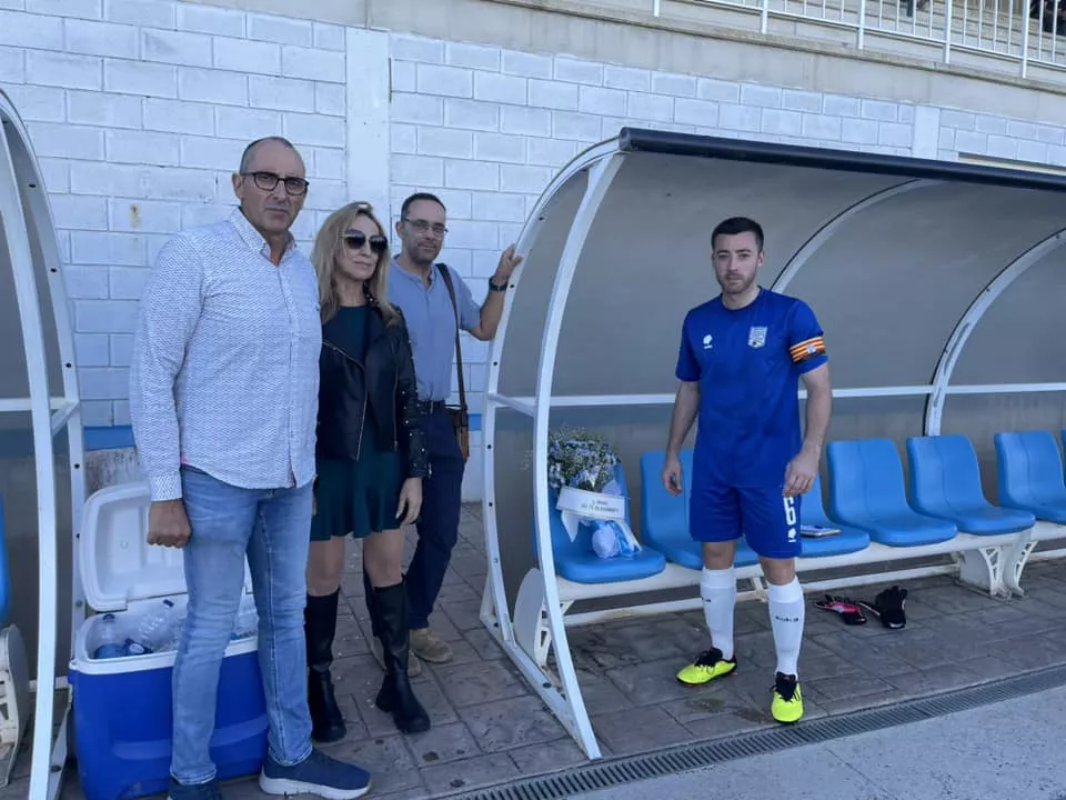 Carlos Villellas, capitán del Sariñena, coloca un ramo de flores en el banquillo en honor a Manu Tena.