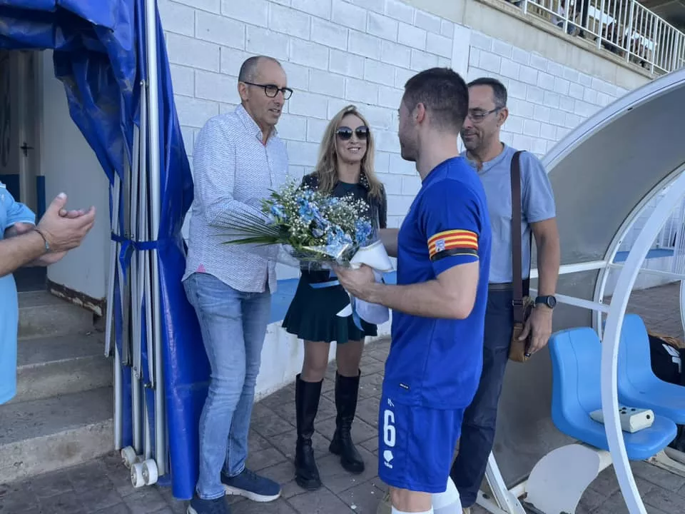 Carlos Villellas, capitán del Sariñena, coloca un ramo de flores en el banquillo en honor a Manu Tena.