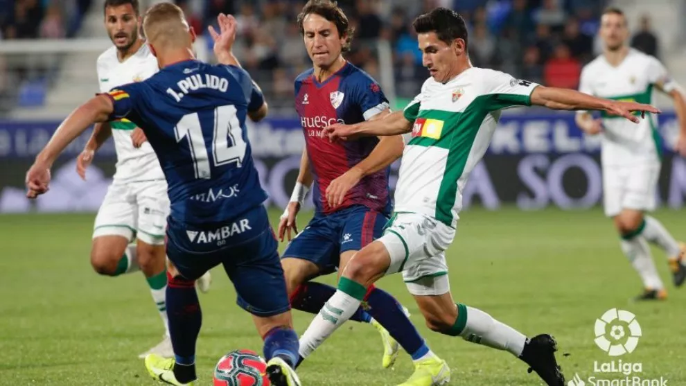 Jorge Pulido, capitán del Huesca, disputa un balón en un Huesca-Elche en El Alcoraz.