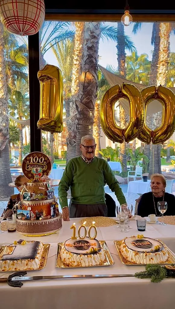 Albero y su mujer ante la tarta del centenario.