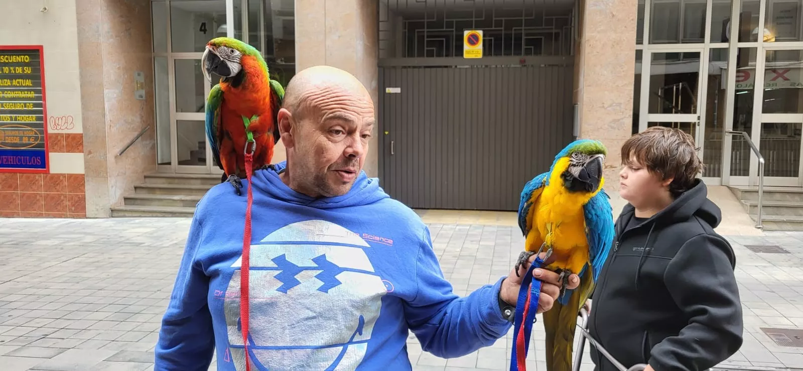 Fernando, con su hijo y los loros Colorín y Tabi