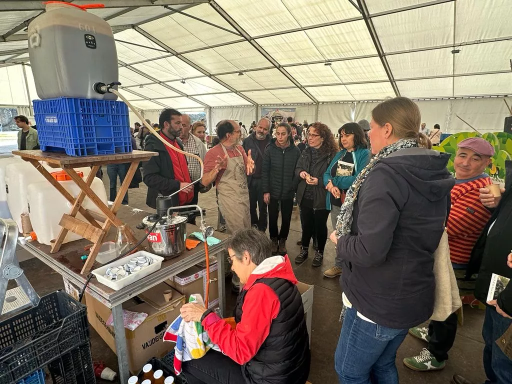 Juan García explicando el proceso de elaboración del zumo de manzana a participantes del encuentro de la Red