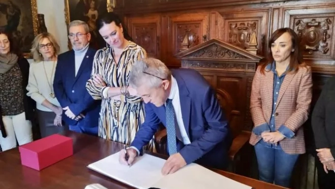Samper firma en el libro de honor del Ayuntamiento de Huesca.