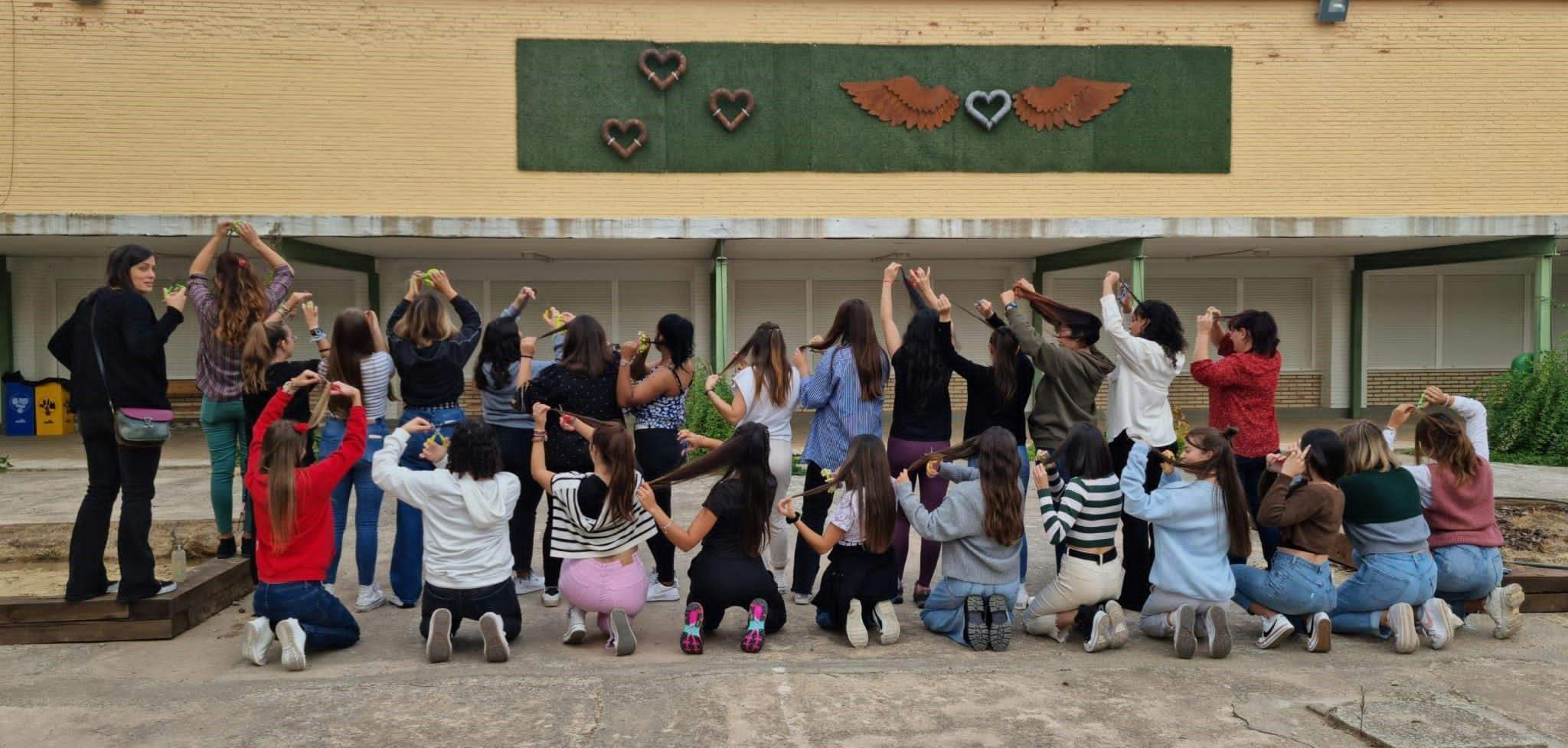 Las alumnas de segundo de Educación Infantil, en el patio ante la escultura del ciclo de Soldadura y cortándose un mechón de cabello.