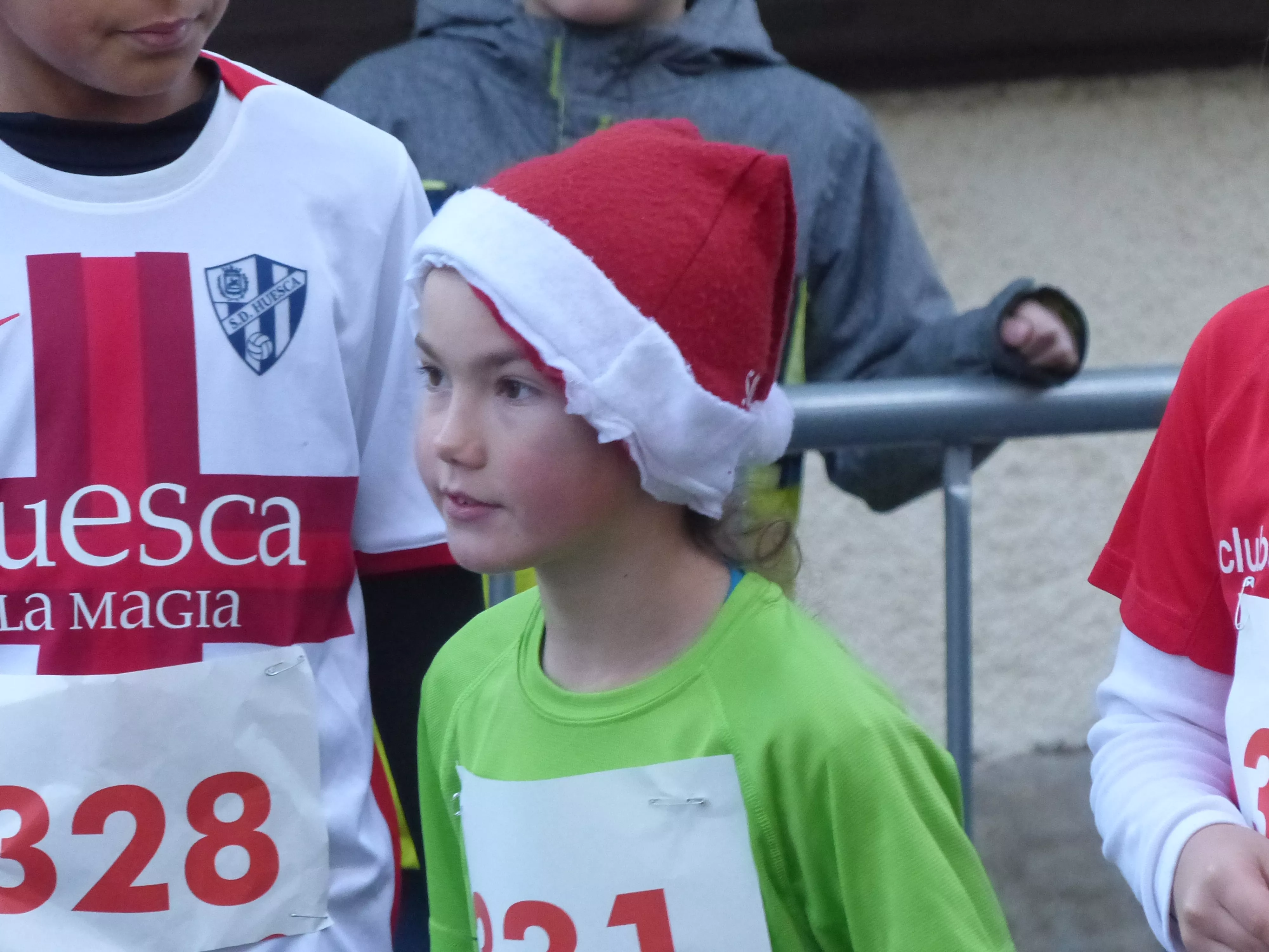 Un benjamín junto al escudo del Huesca. Foto: Andrés Alcaraz