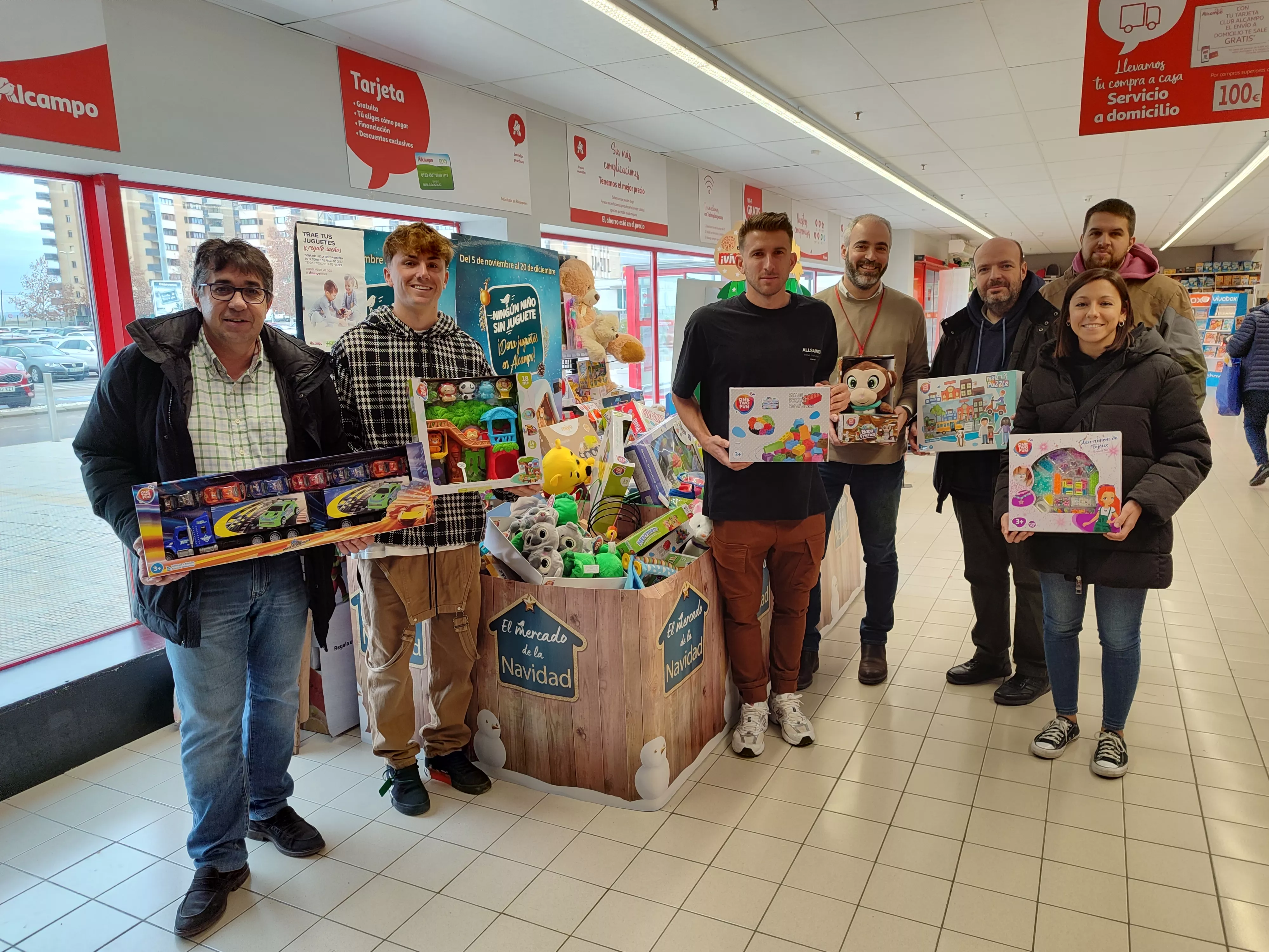 Javier Cruz, Manu Rico y Gerard Valentín con representantes de Cruz Blanca en el acto de entrega de juguetes. Foto: SD Huescala entrega.