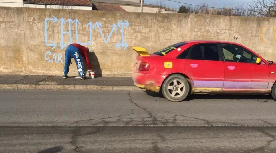 Chuvi haciendo una pintada, junto a su coche. Ha sido detenido por la Guardia Civil