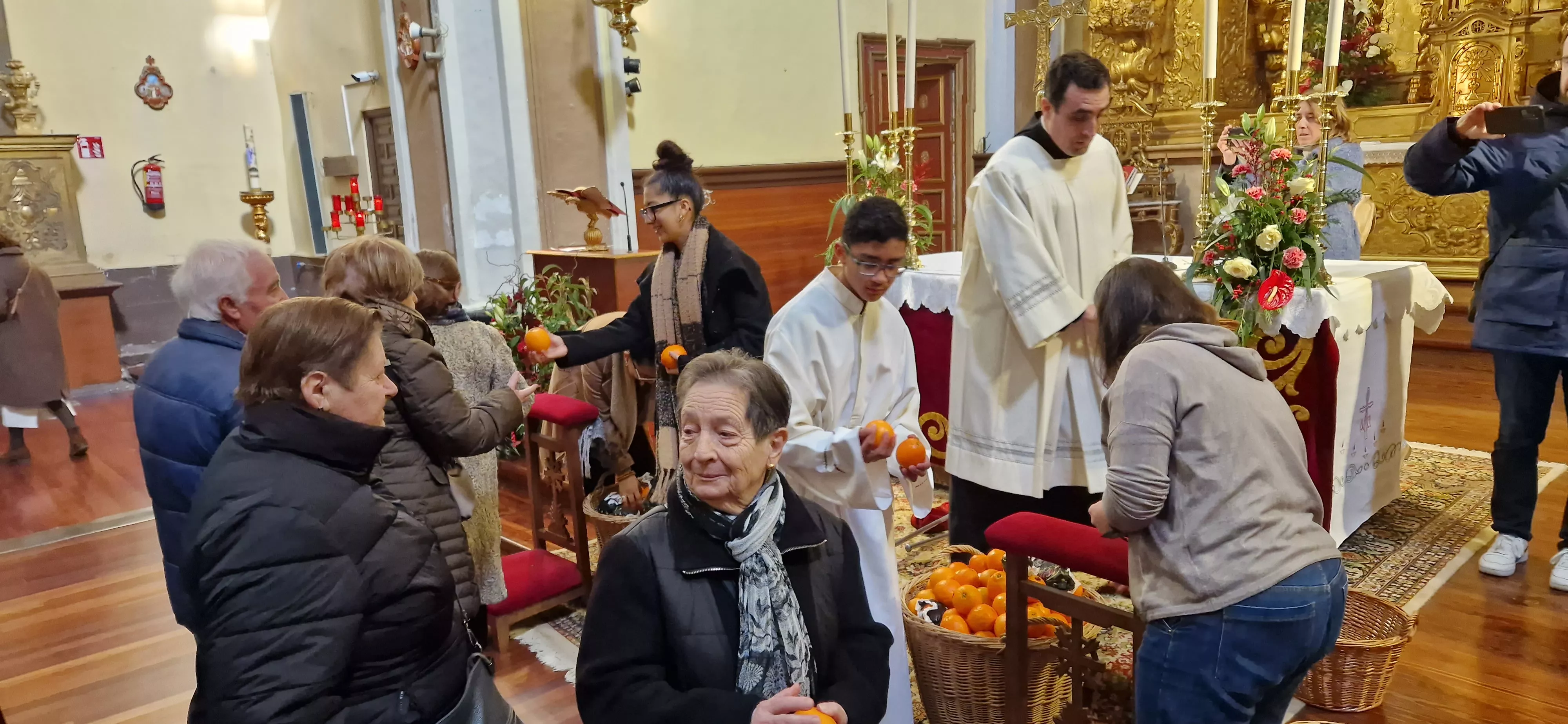 Reparto de naranjas en la Iglesia de San Vicente. Foto Myriam Martínez 