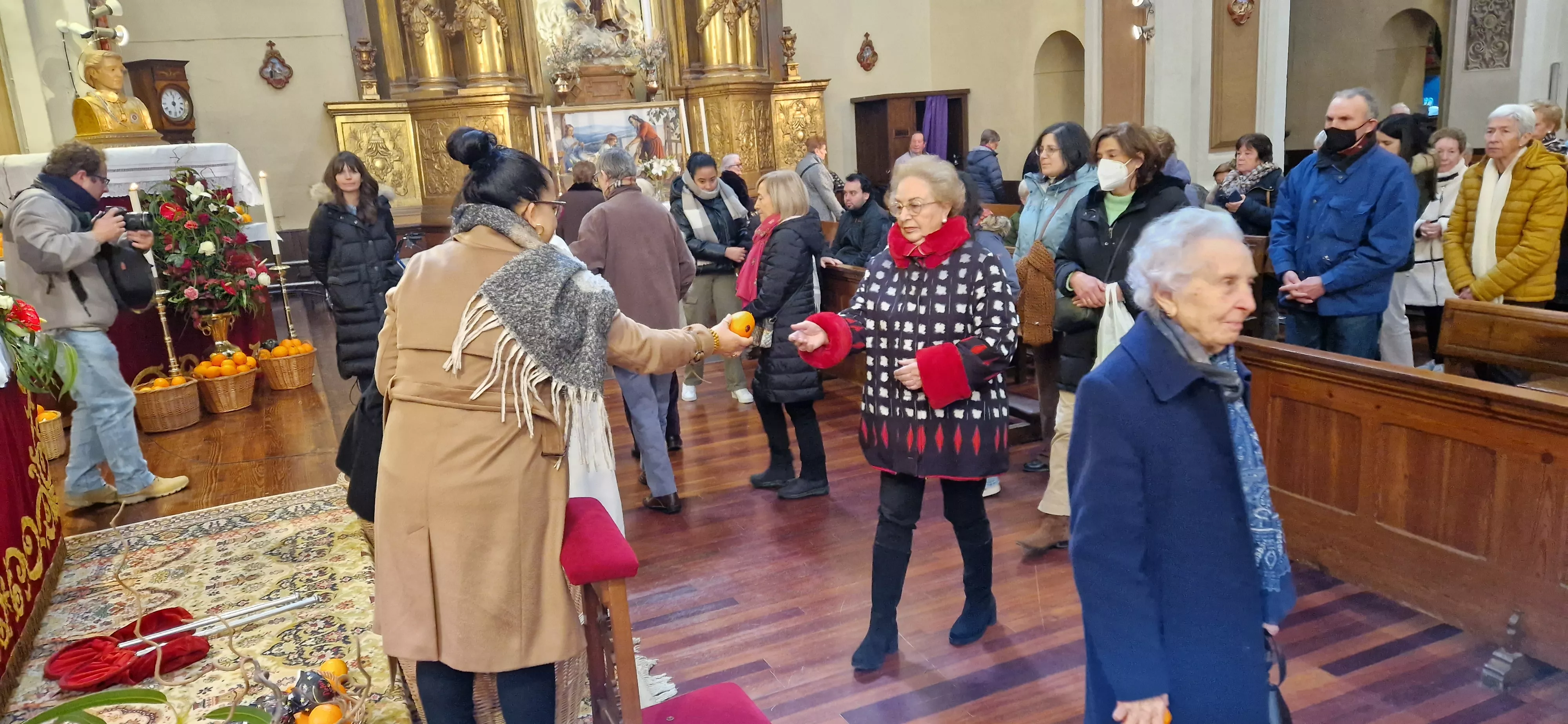 Reparto de naranjas en la Iglesia de San Vicente. Foto Myriam Martínez 