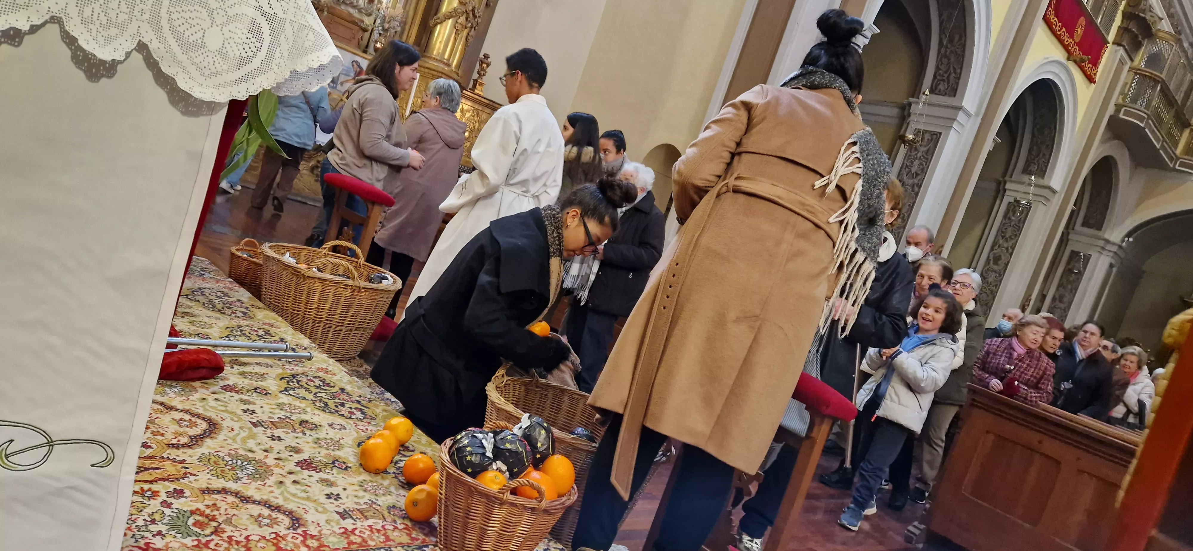 Reparto de naranjas en la Iglesia de San Vicente. Foto Myriam Martínez 