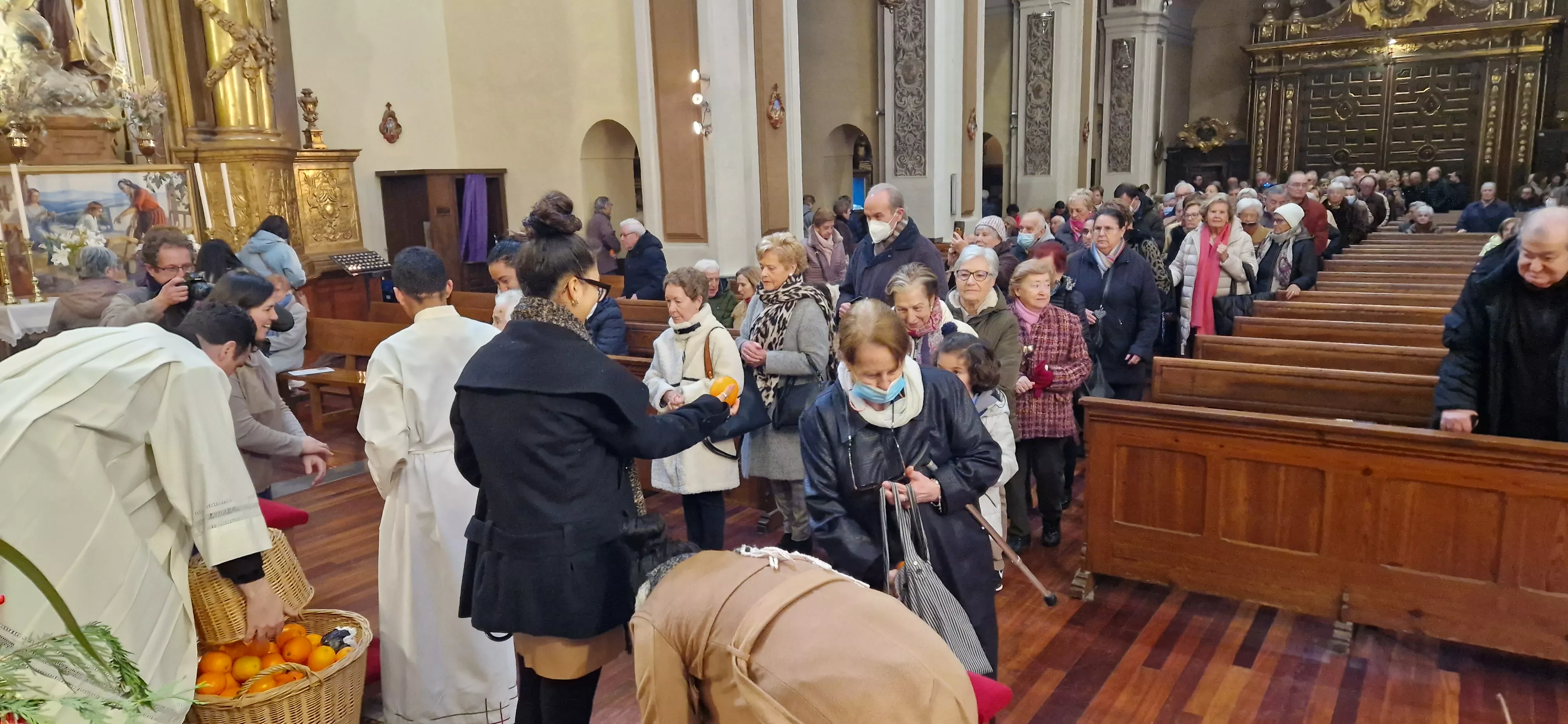 Reparto de naranjas en la Iglesia de San Vicente. Foto Myriam Martínez 