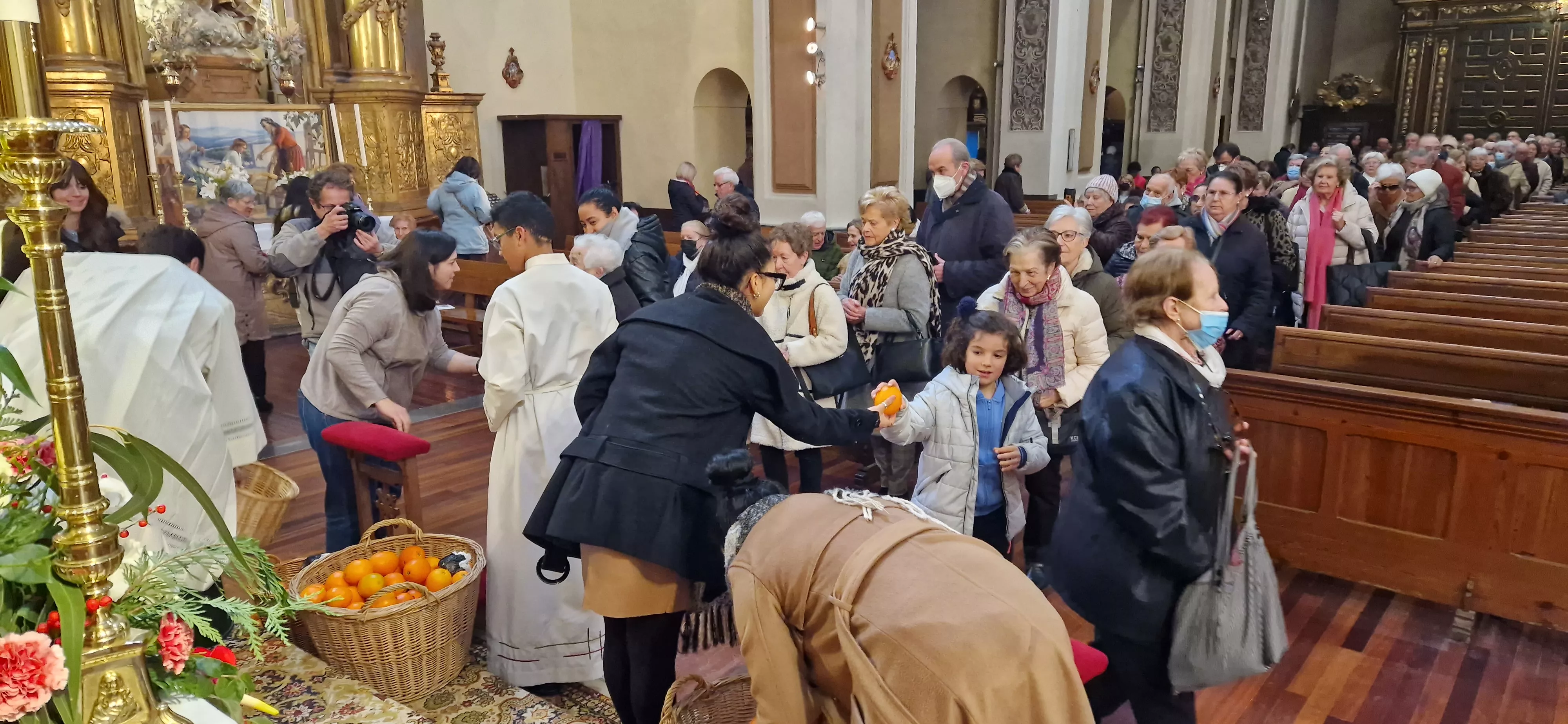 Reparto de naranjas en la Iglesia de San Vicente. Foto Myriam Martínez 
