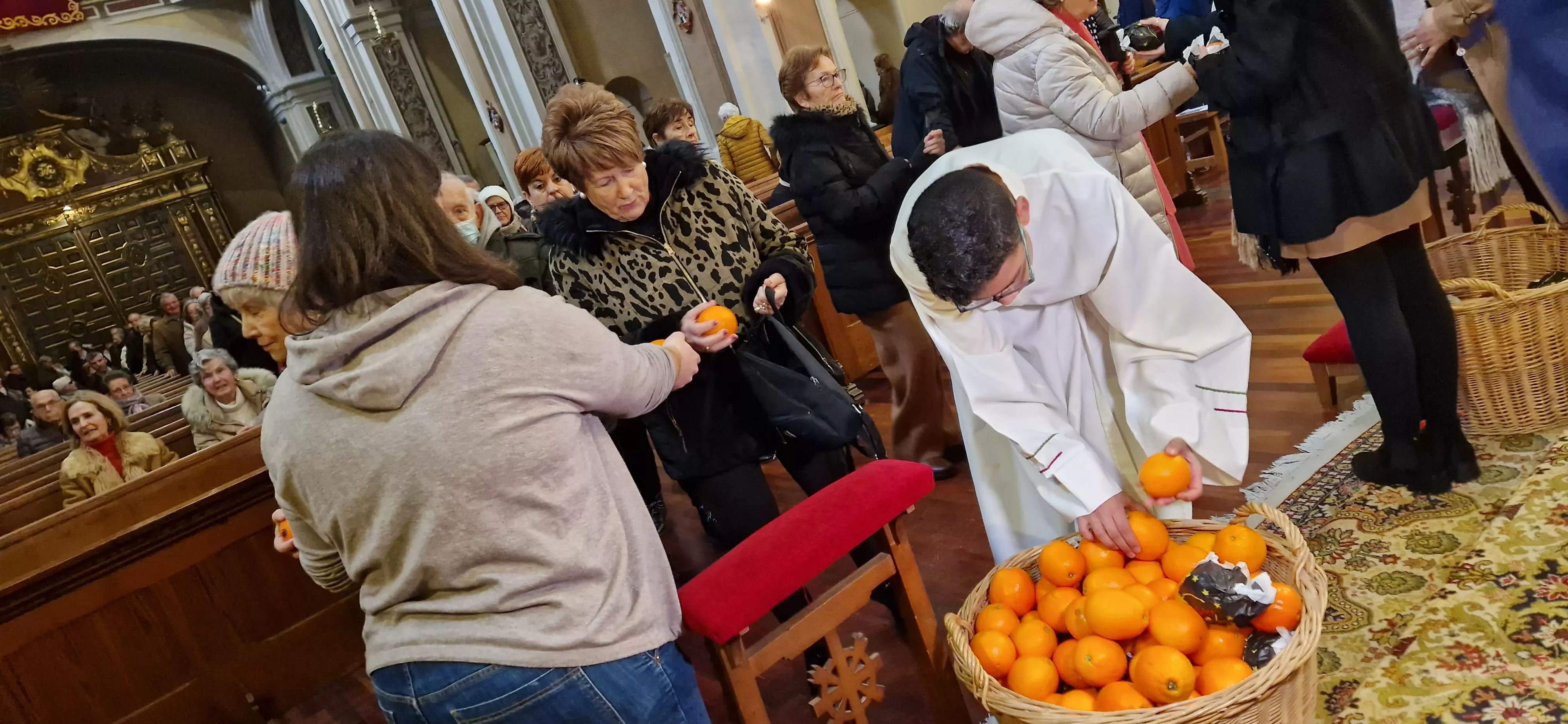 Reparto de naranjas en la Iglesia de San Vicente. Foto Myriam Martínez 