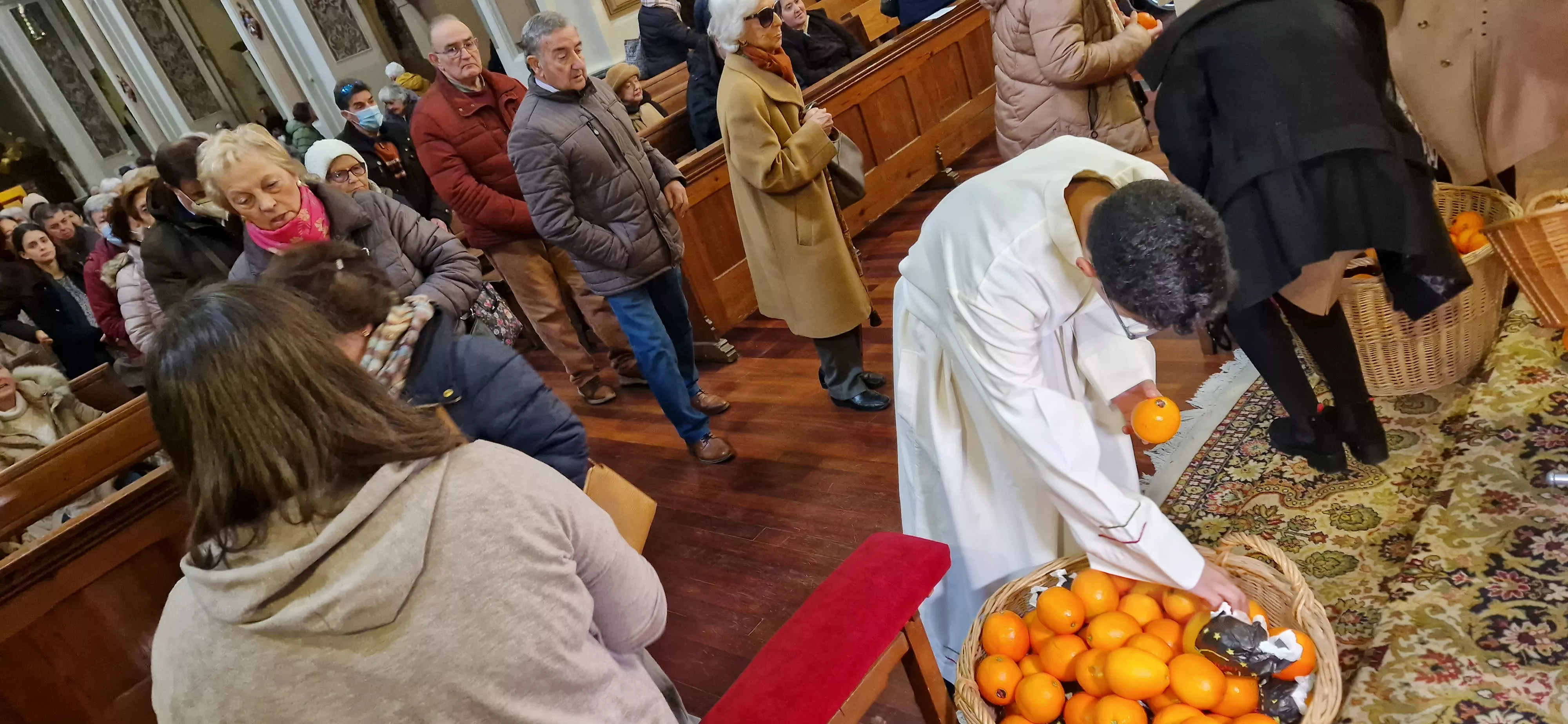 Reparto de naranjas en la Iglesia de San Vicente. Foto Myriam Martínez 