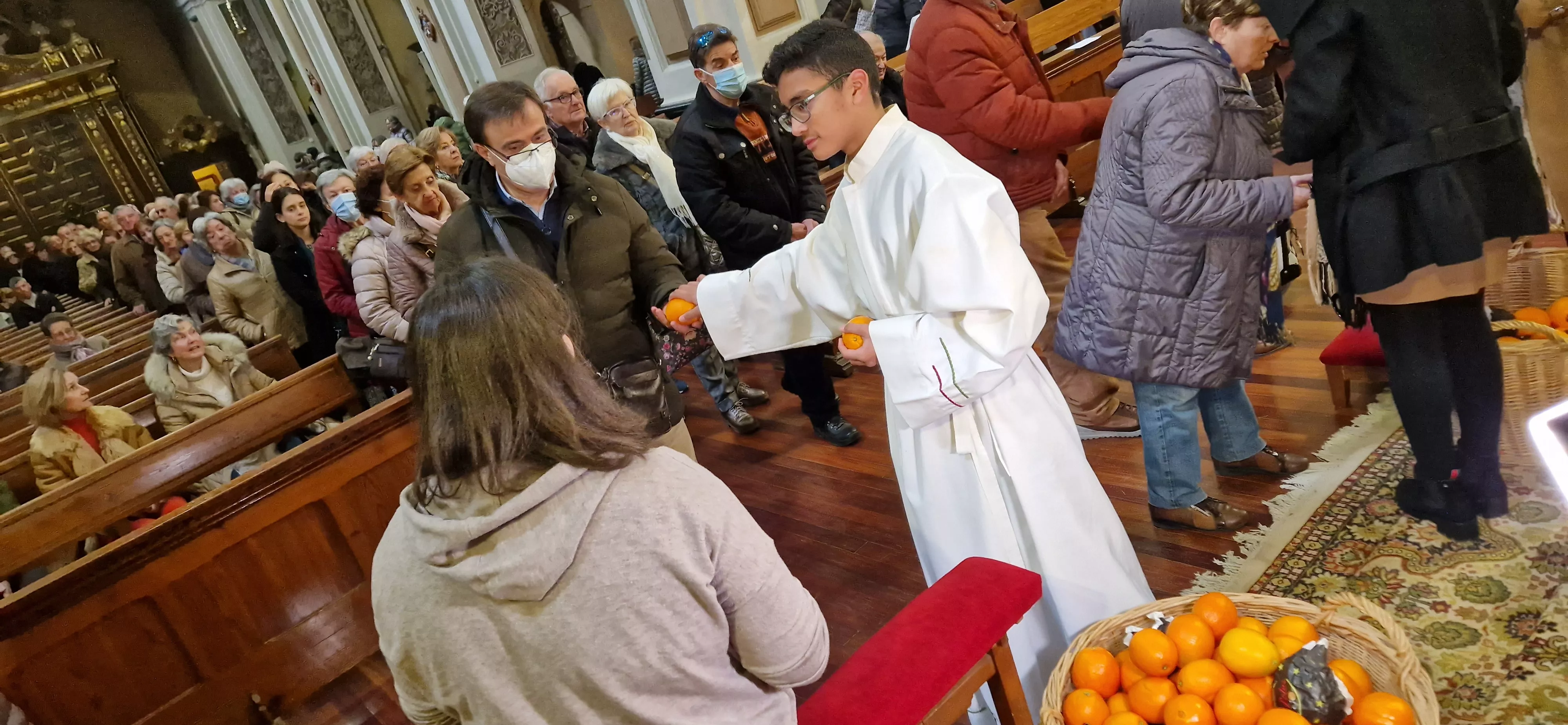 Reparto de naranjas en la Iglesia de San Vicente. Foto Myriam Martínez 