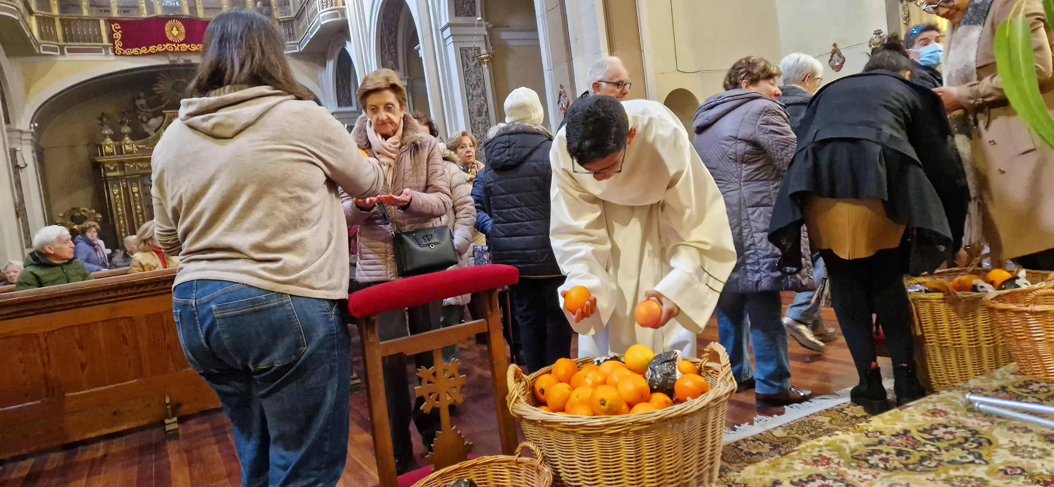 Reparto de naranjas en la Iglesia de San Vicente. Foto Myriam Martínez 