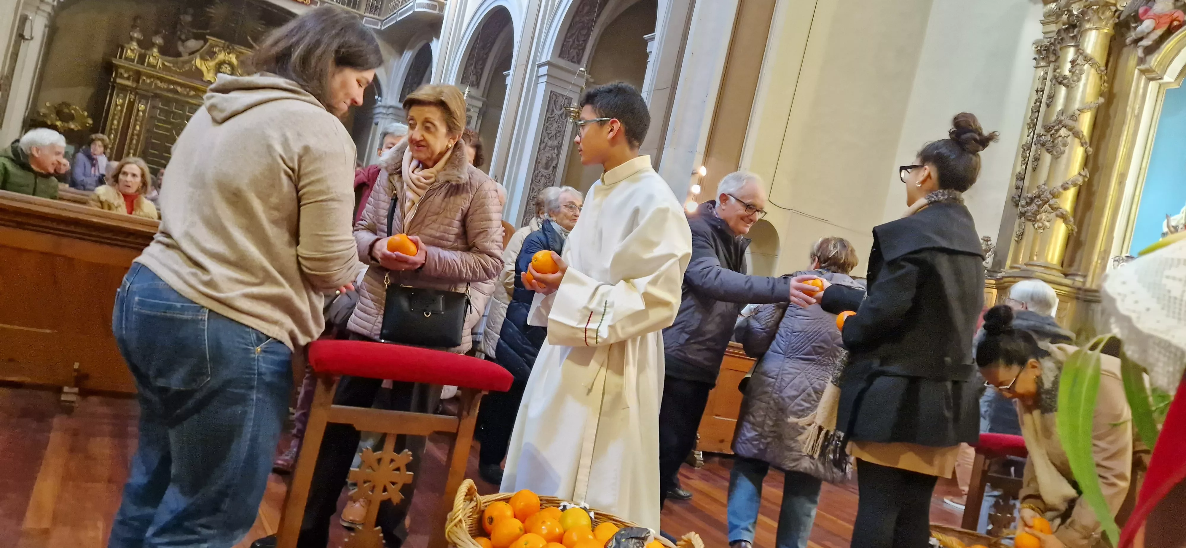 Reparto de naranjas en la Iglesia de San Vicente. Foto Myriam Martínez 