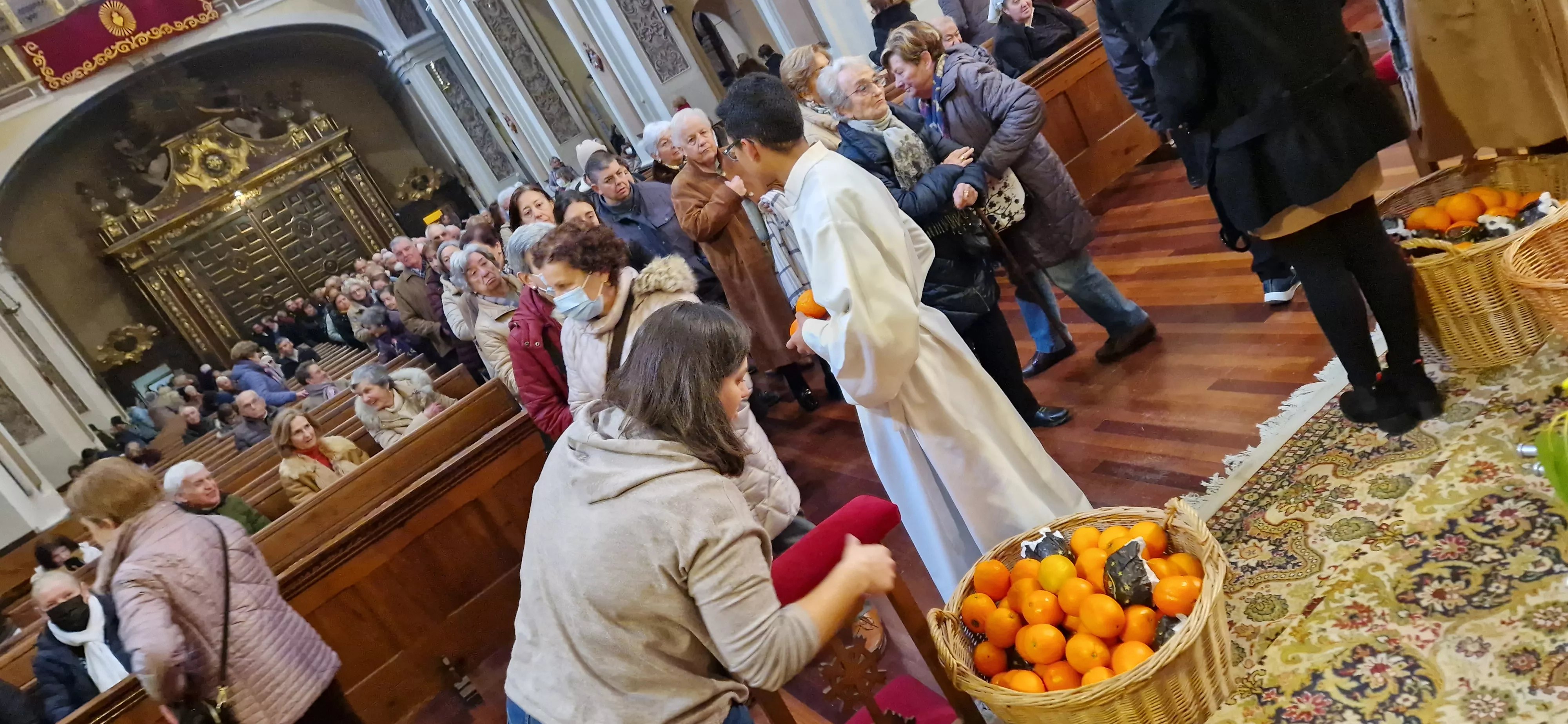 Reparto de naranjas en la Iglesia de San Vicente. Foto Myriam Martínez 