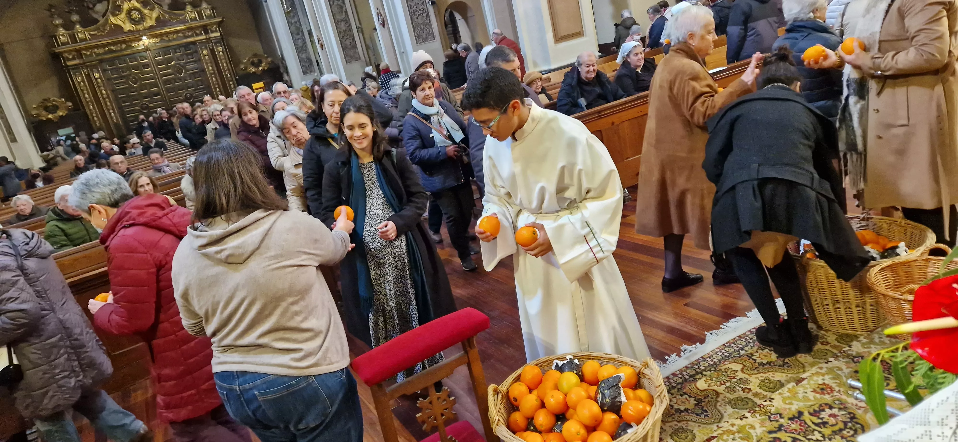 Reparto de naranjas en la Iglesia de San Vicente. Foto Myriam Martínez 