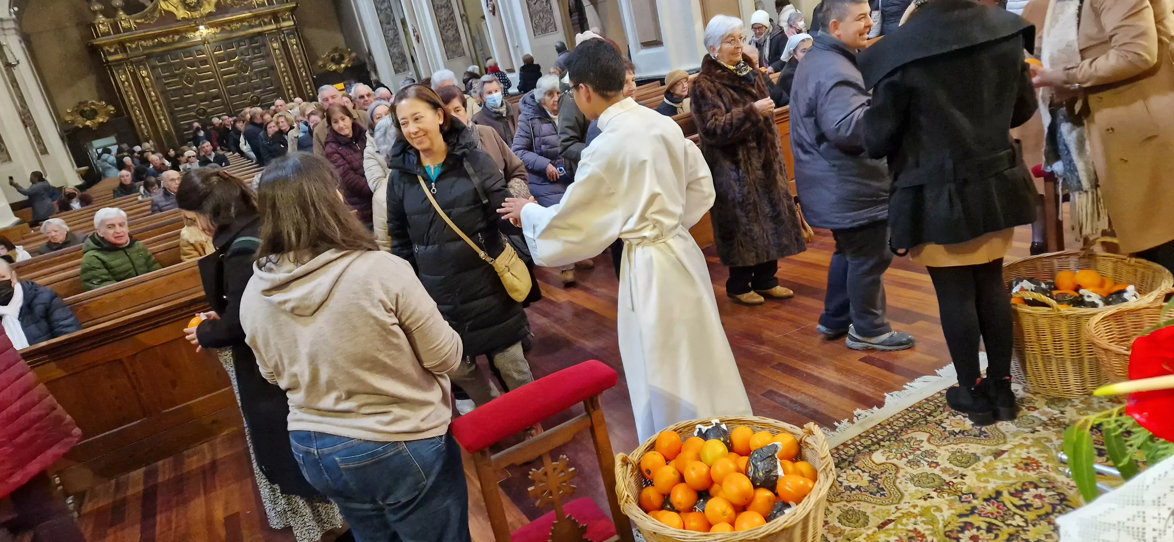 Reparto de naranjas en la Iglesia de San Vicente. Foto Myriam Martínez 