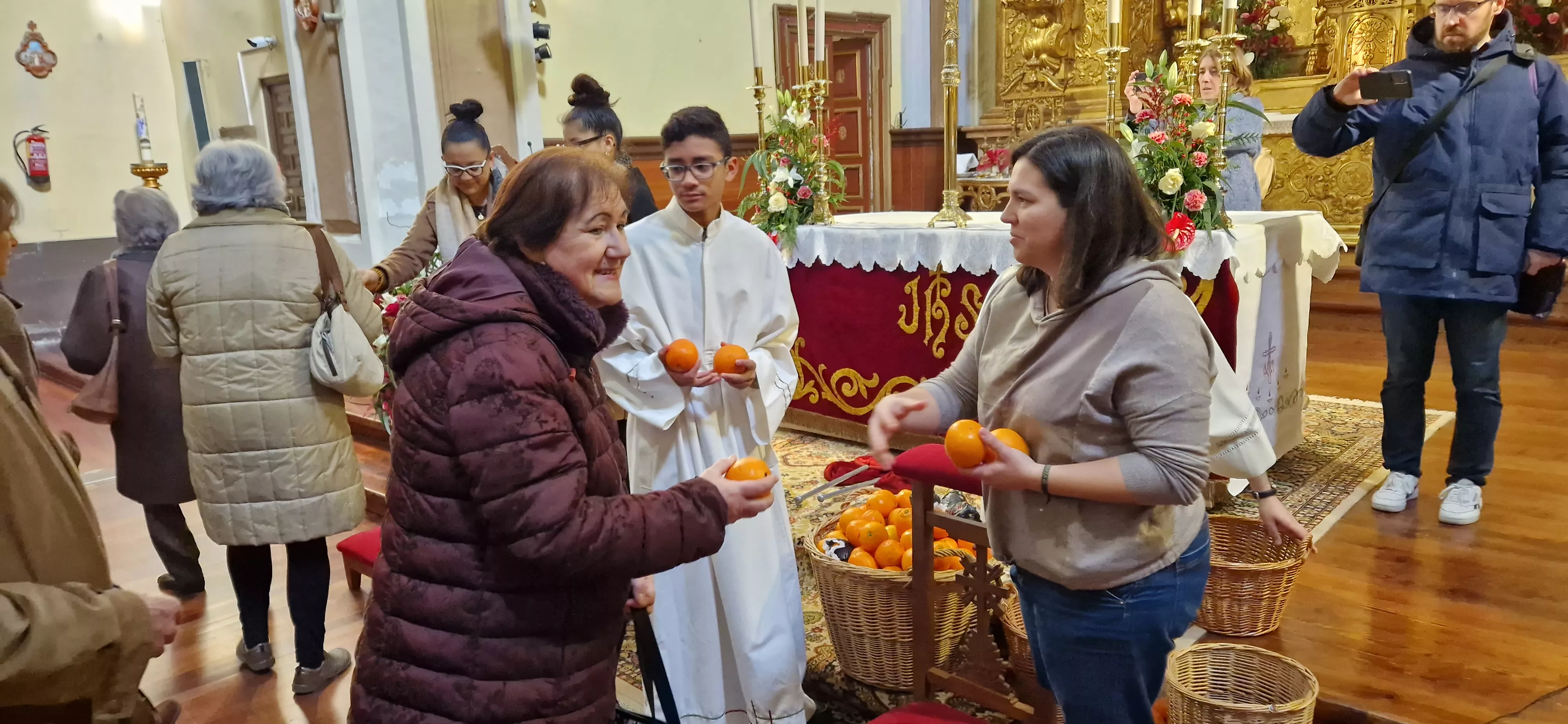 Reparto de naranjas en la Iglesia de San Vicente. Foto Myriam Martínez 