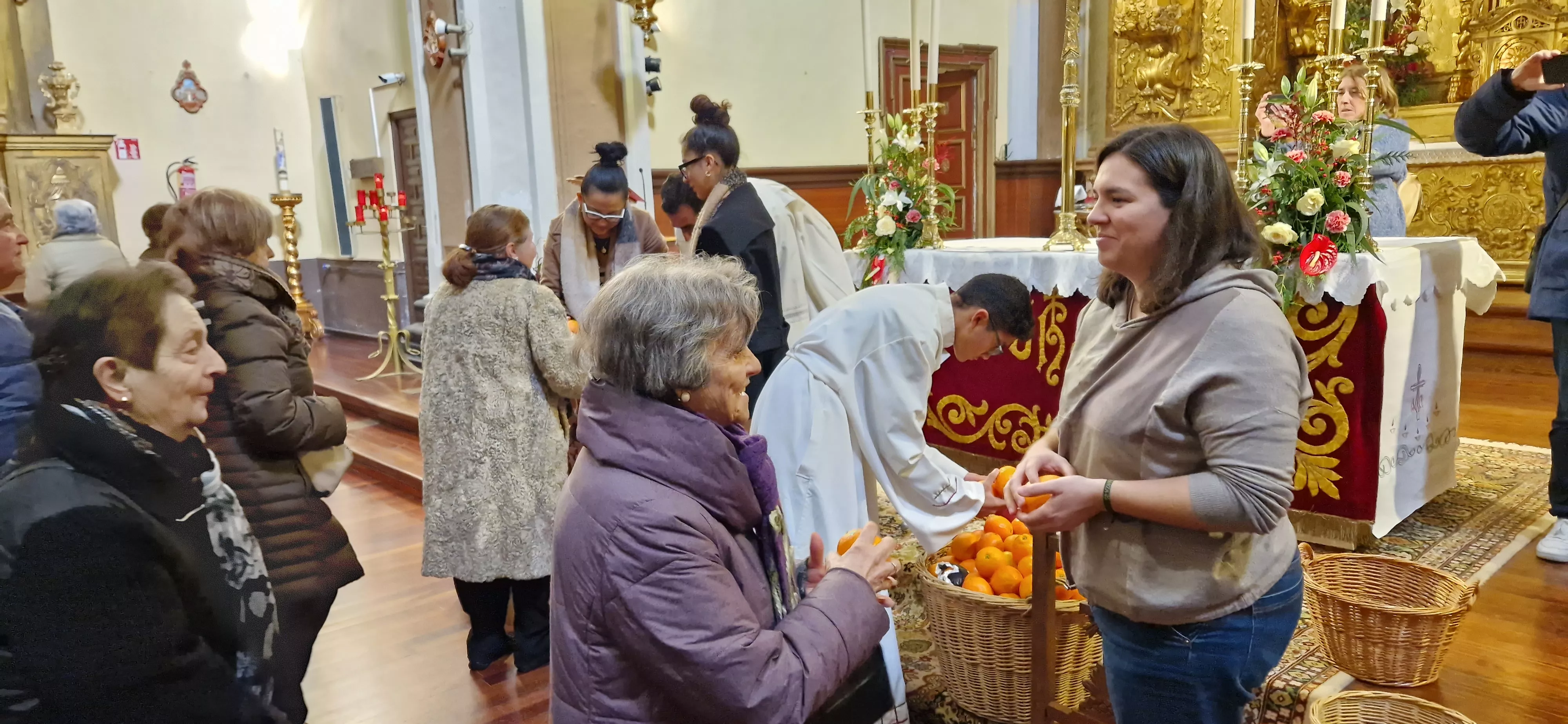 Reparto de naranjas en la Iglesia de San Vicente. Foto Myriam Martínez 
