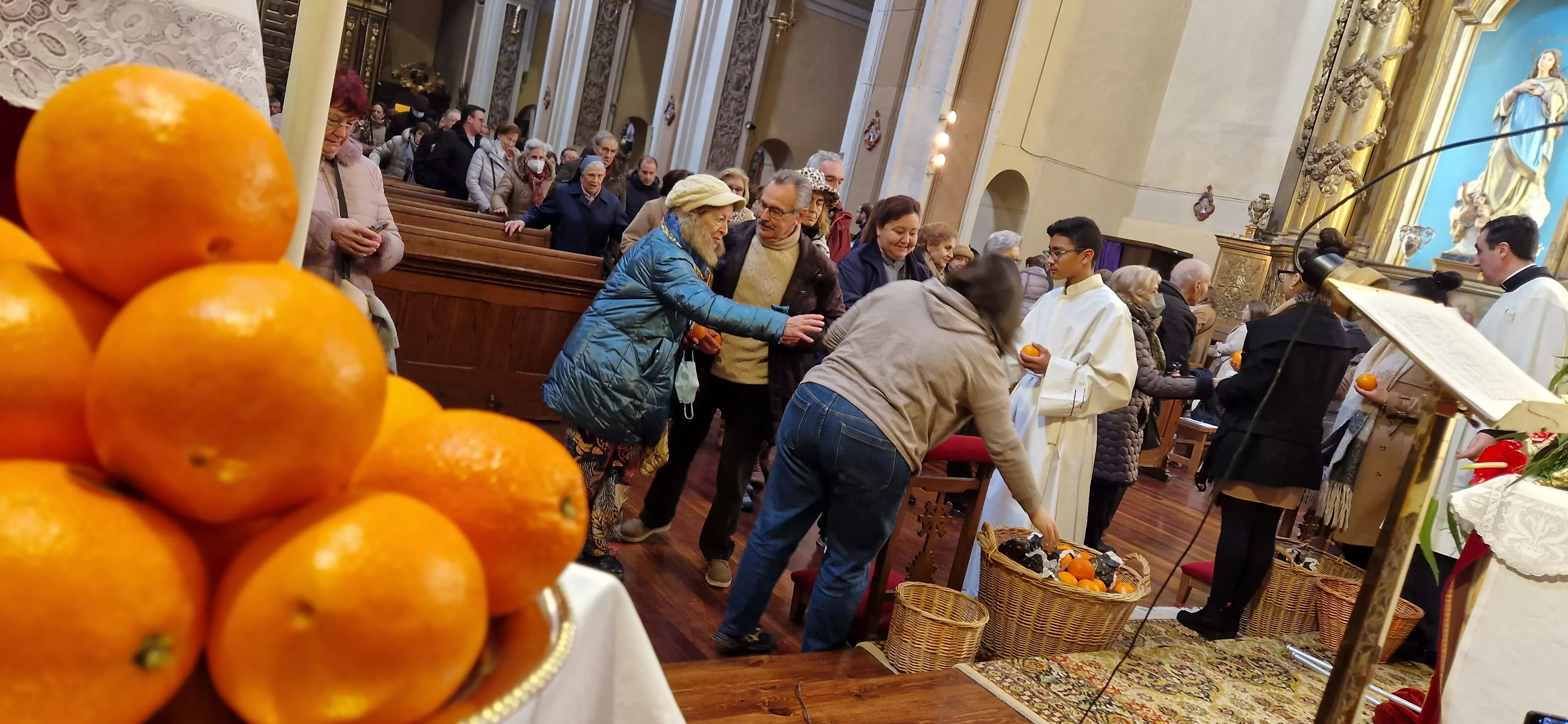 Reparto de naranjas en la Iglesia de San Vicente. Foto Myriam Martínez