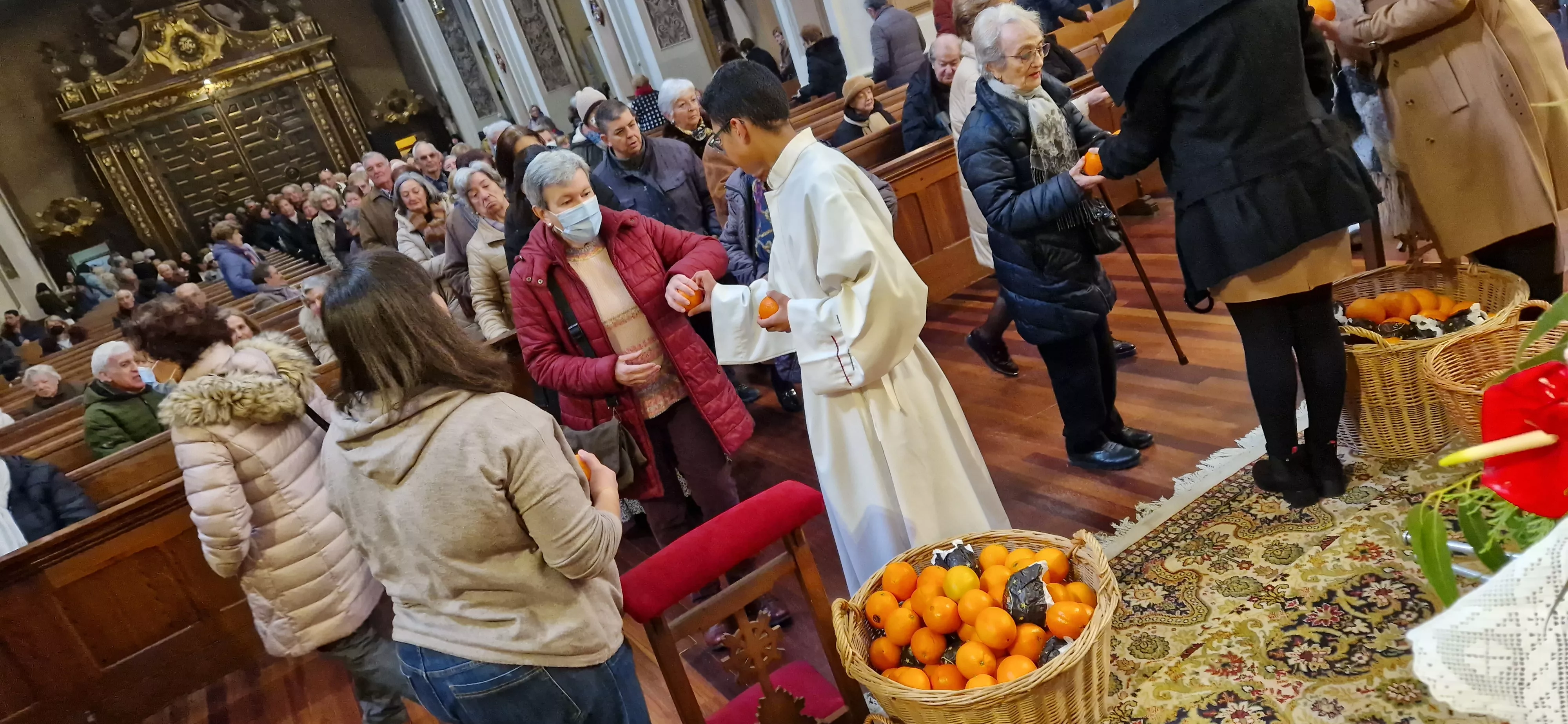 Reparto de naranjas en la Iglesia de San Vicente. Foto Myriam Martínez 