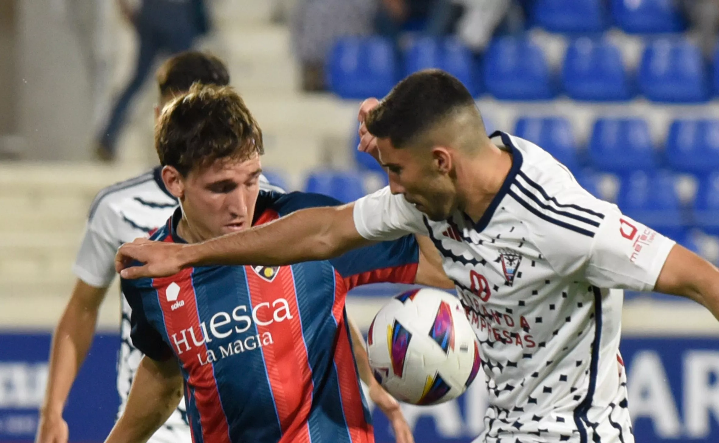 Kortajarena y Tachi, jugadores de Huesca y Mirandés, pugnan por un balón en el choque de ida. Kortajarena y Tachi, jugadores de Huesca y Mirandés, pugnan por un balón en el choque de ida.