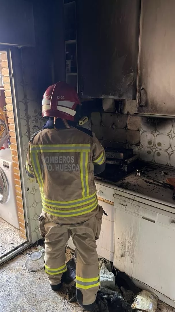 Un bombero interviene en la cocina en  la plaza Lérida de Huesca