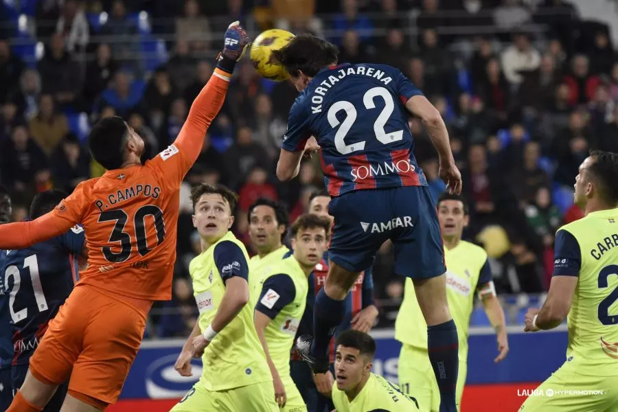 Kortajarena, jugador del Huesca, cabecea un envío ante la salida de Cuñat.