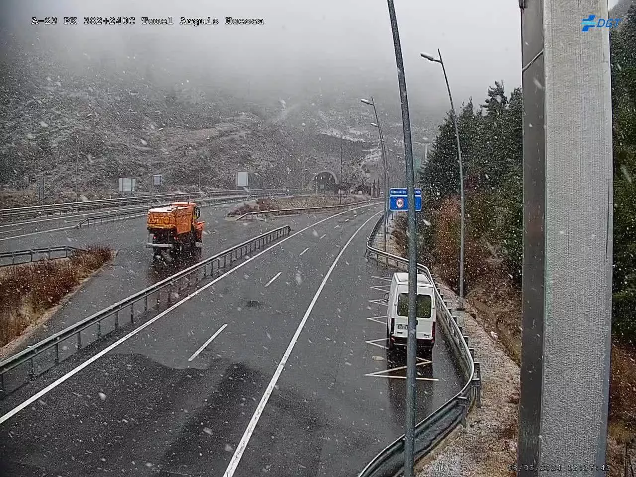 Imagen de la nieve que cae este mediodía en el túnel de Arguis, con una máquina quitanieves dispuesta en la zona.