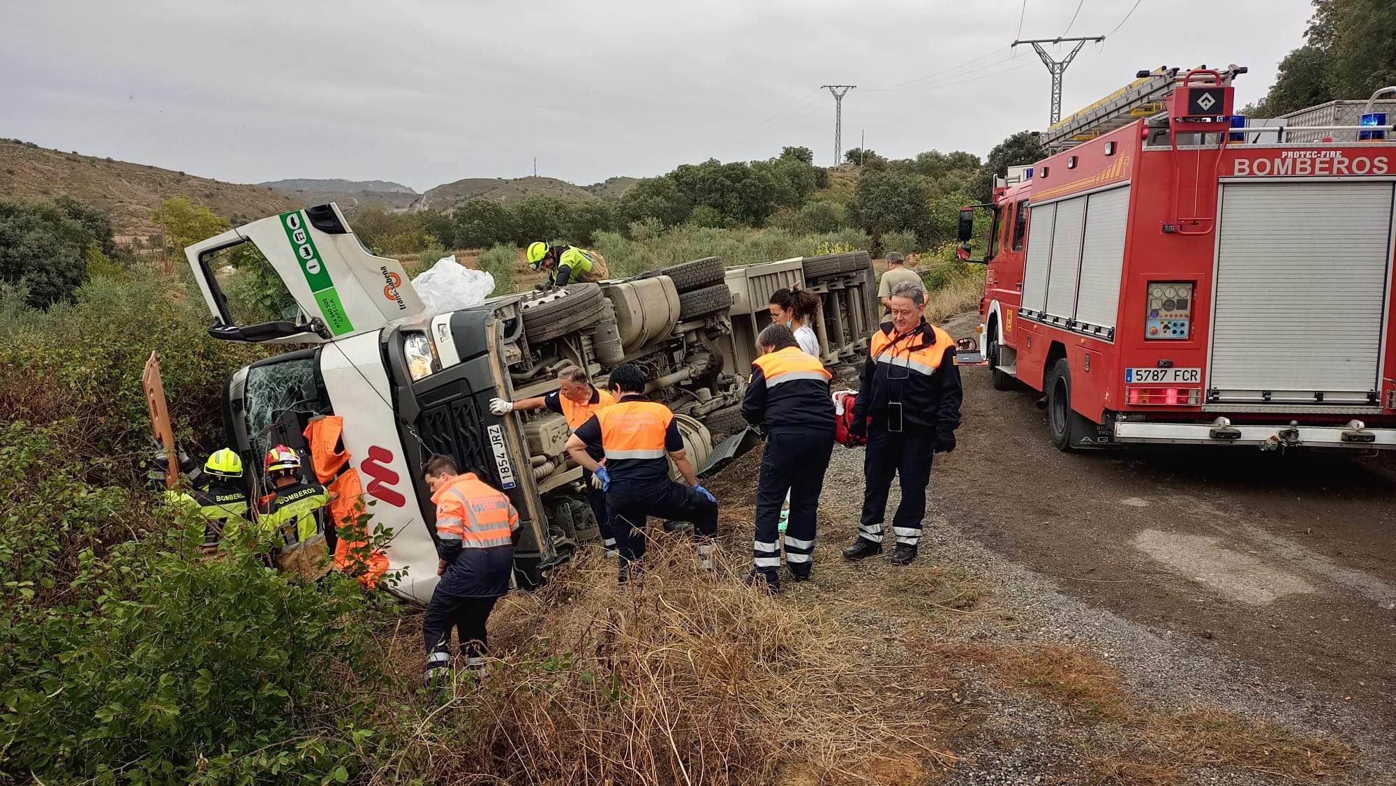 Los bomberos auxilian al conductor de un camión que había quedado atrapado en la cabina tras el accidente