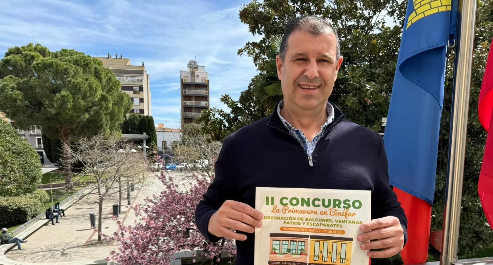Sergio Serra muestra el cartel del concurso de decoración floral de fachadas de Binéfar.
