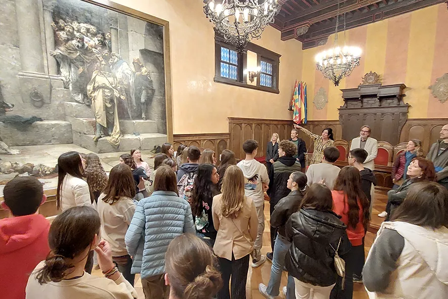 La alcaldesa de Huesca, Lorena Orduna, explica a los estudiantes el cuadro de la Campana en el Ayuntamiento