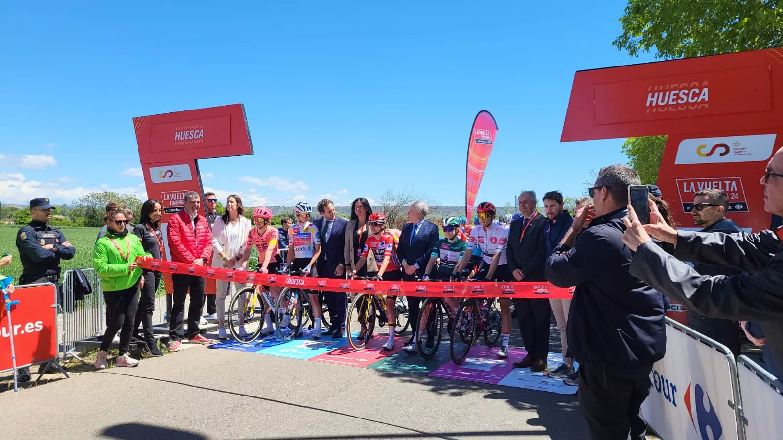 Autoridades, en el corte de cinta protocolario antes de la salida de la quinta etapa de la Vuelta Femenina desde Huesca. Foto: Adrián Mora
