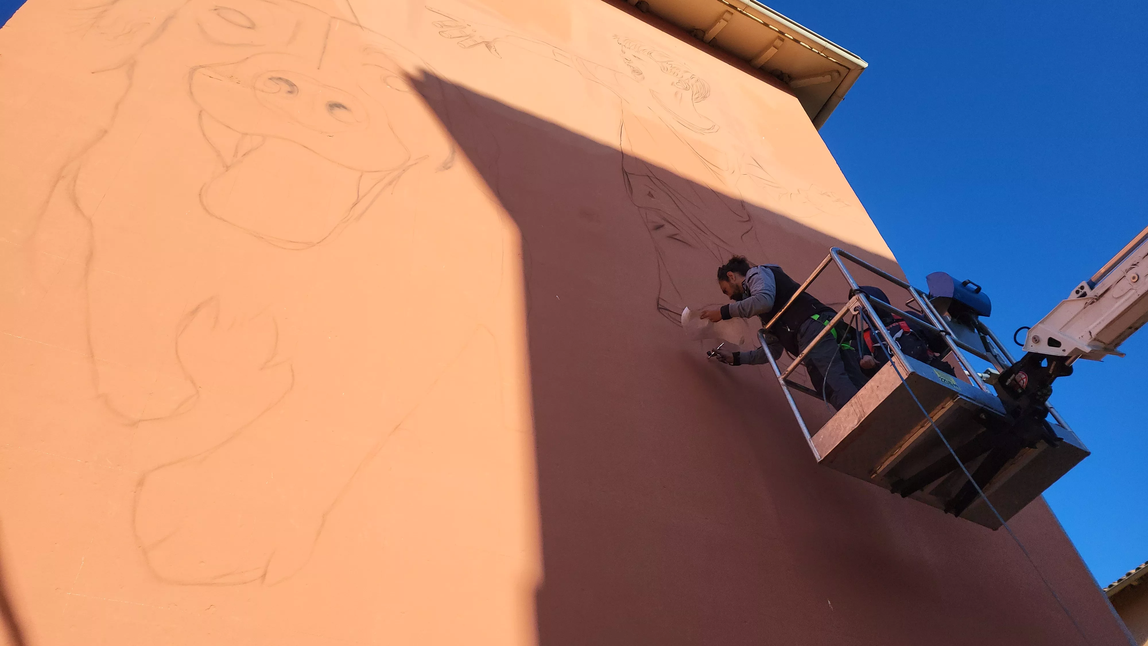 Gatta y Camarero trabajan en el mural en una fachada de la plaza Federico Mayo. Foto Mercedes Manterola
