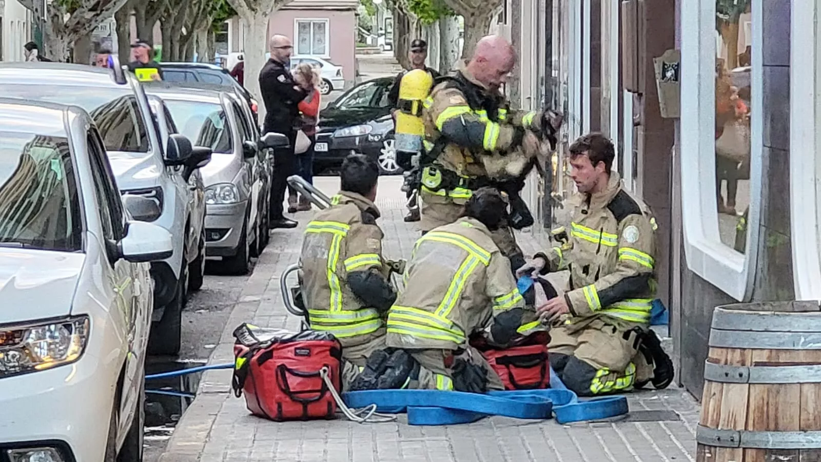 Bomberos recogiendo las mangueras usadas para controlar y sofocar el incendio