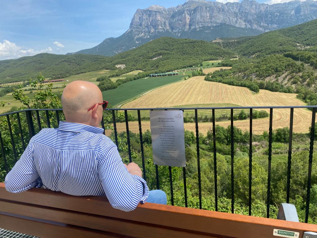 Leyendo poesía en El Pueyo de Araguás con la Peña Montañesa al fondo.
