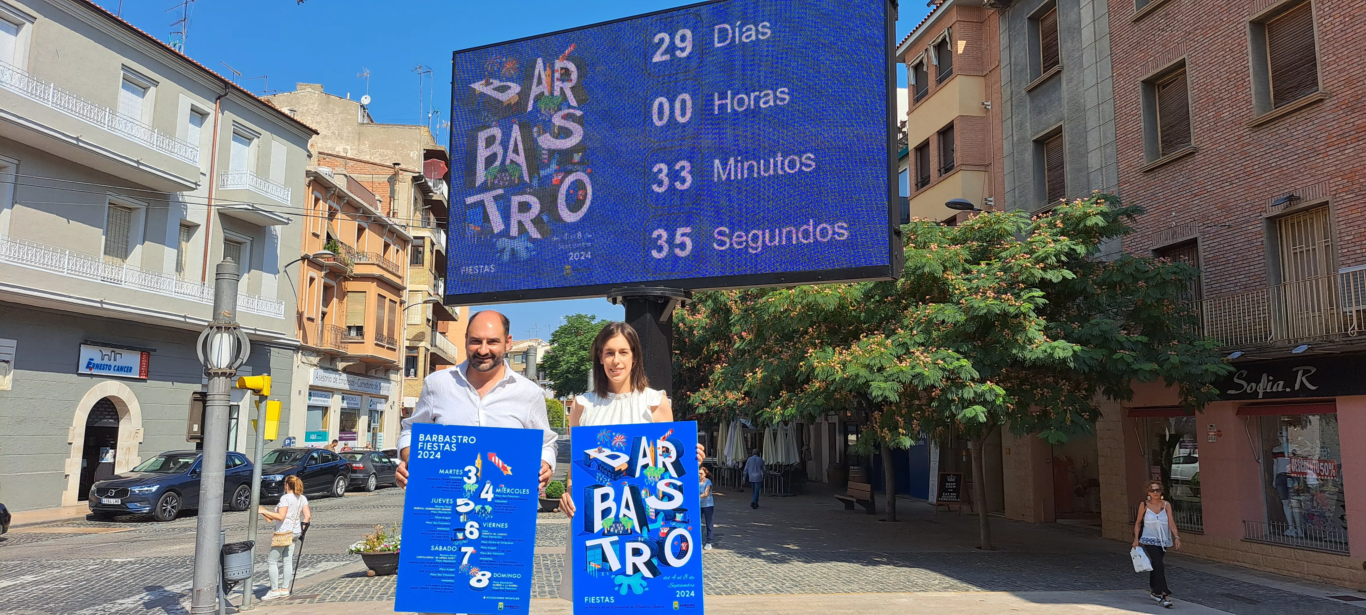 Fernando Torres y Lorena Espierrez con el cartel y material gráfico de las fiestas de Barbastro
