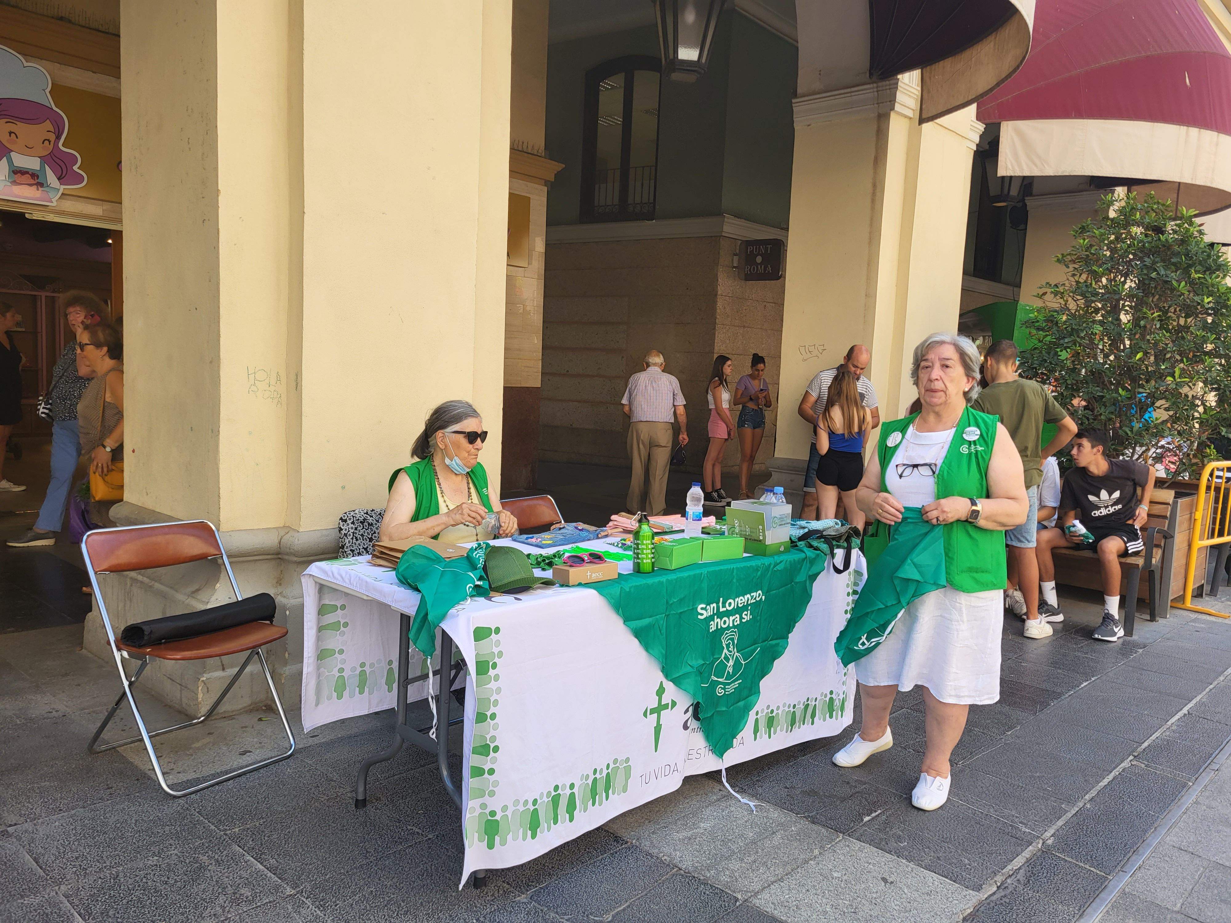 Voluntarias de la Asociación Española contra el Cáncer de Huesca venden pañoletas para San Lorenzo 