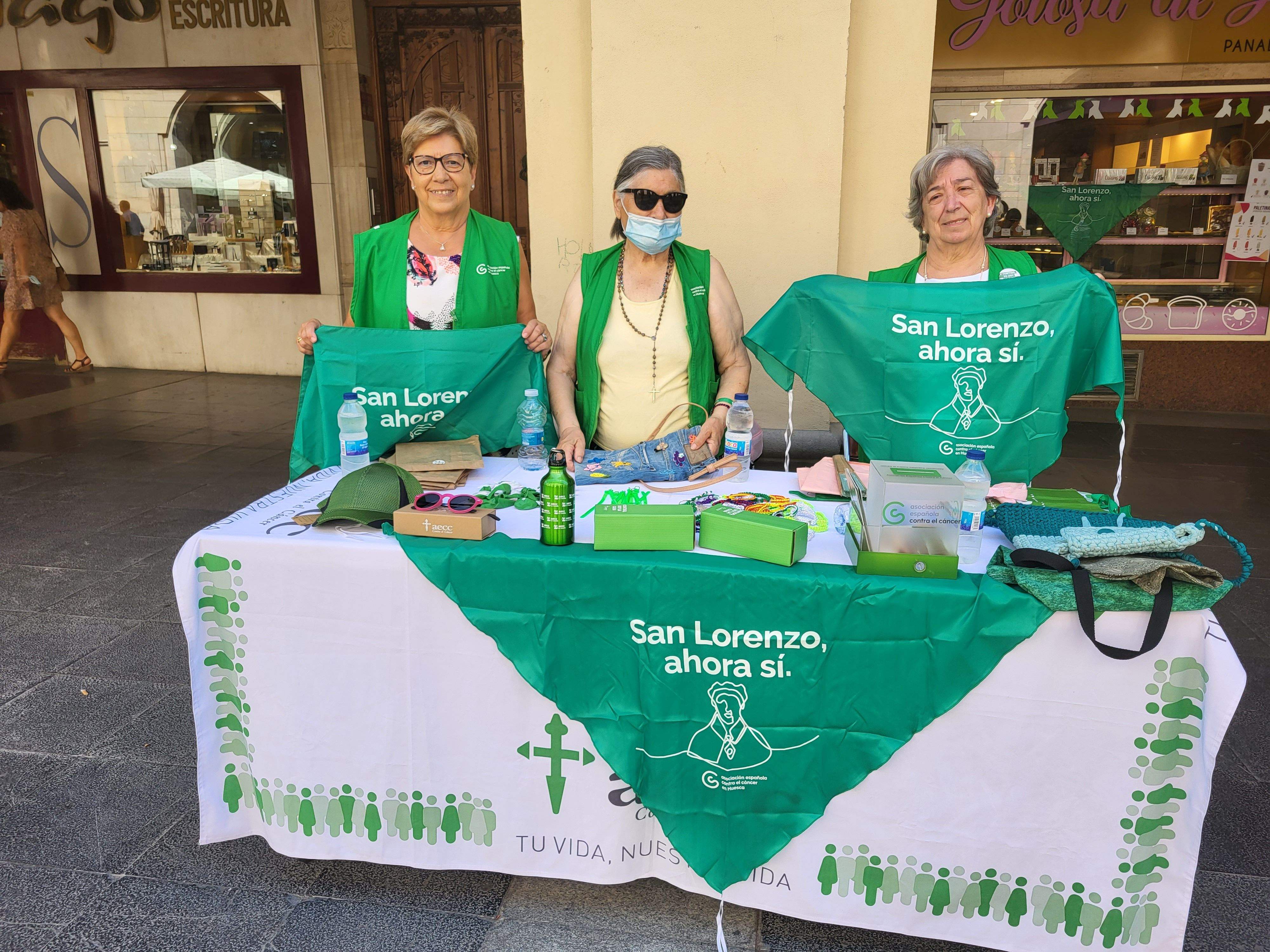 Voluntarias de la Asociación Española contra el Cáncer de Huesca venden pañoletas para San Lorenzo