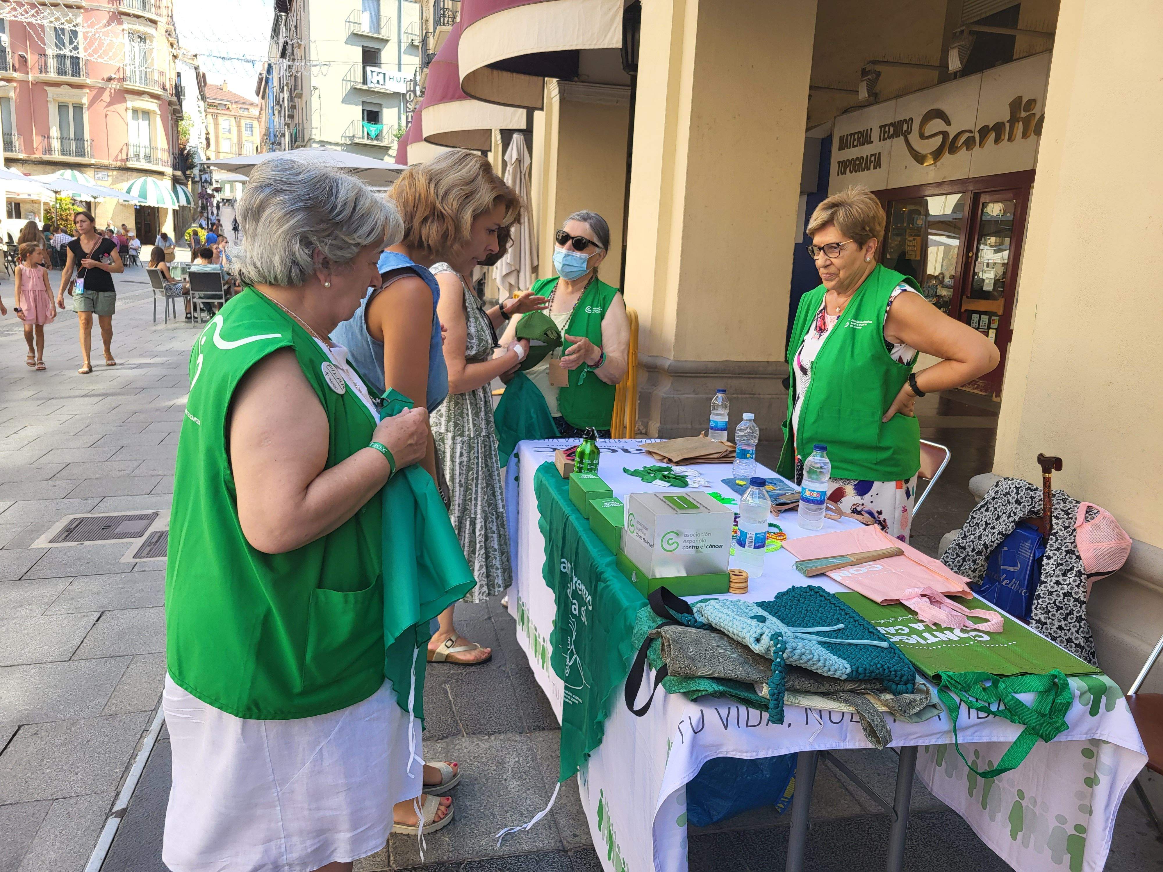Voluntarias de la Asociación Española contra el Cáncer de Huesca venden pañoletas para San Lorenzo 