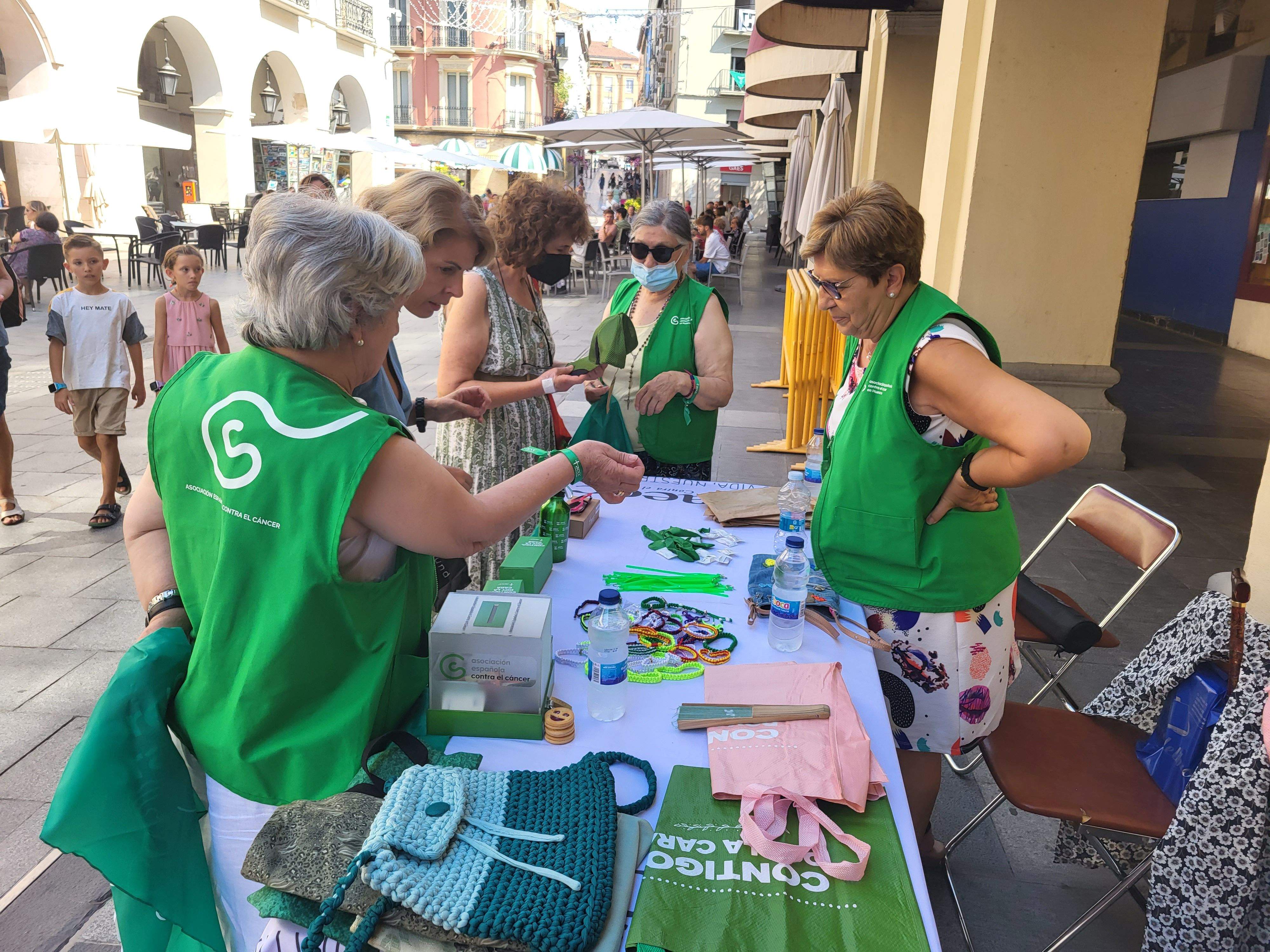 Voluntarias de la Asociación Española contra el Cáncer de Huesca venden pañoletas para San Lorenzo