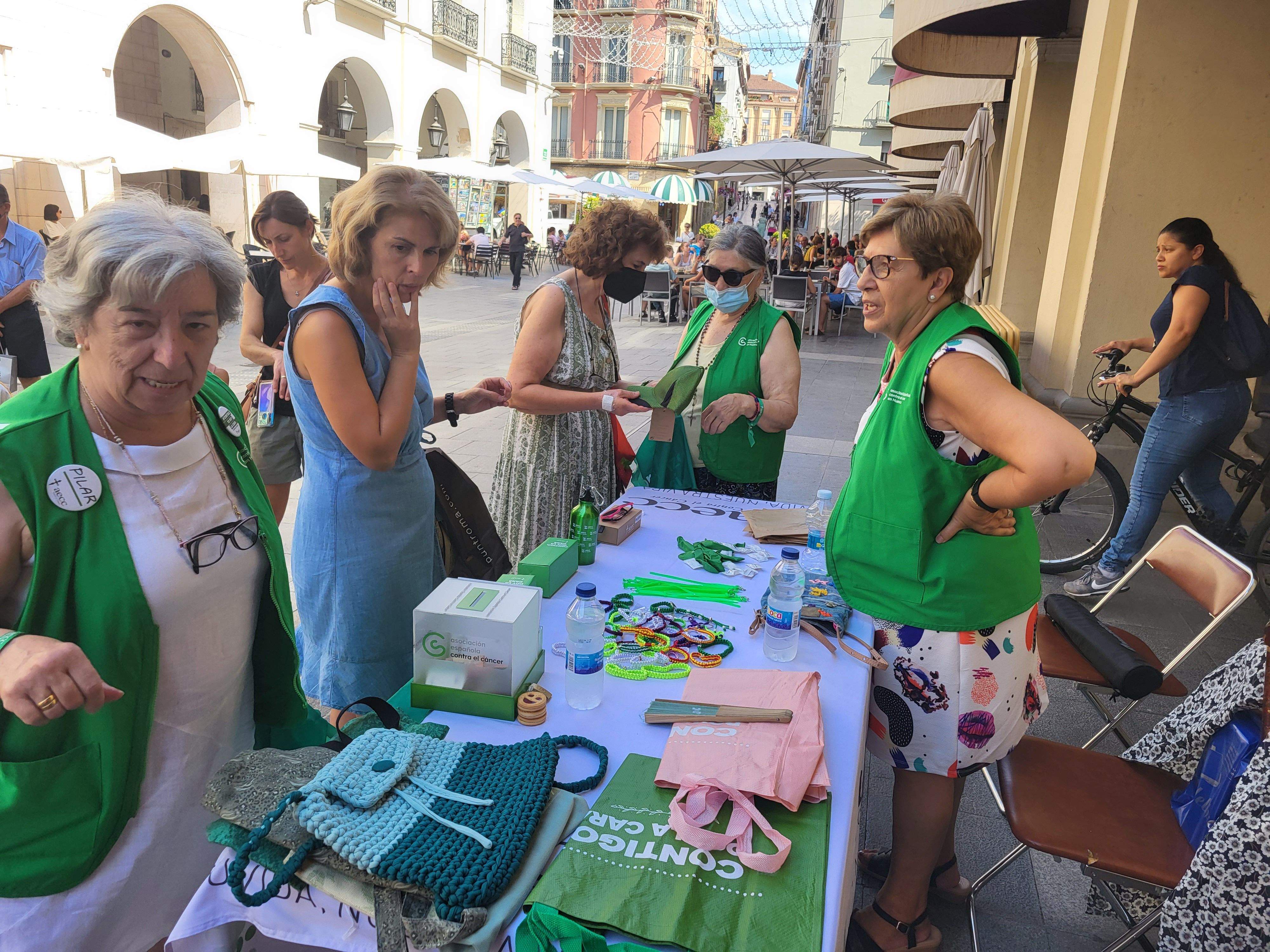 Voluntarias de la Asociación Española contra el Cáncer de Huesca venden pañoletas para San Lorenzo 