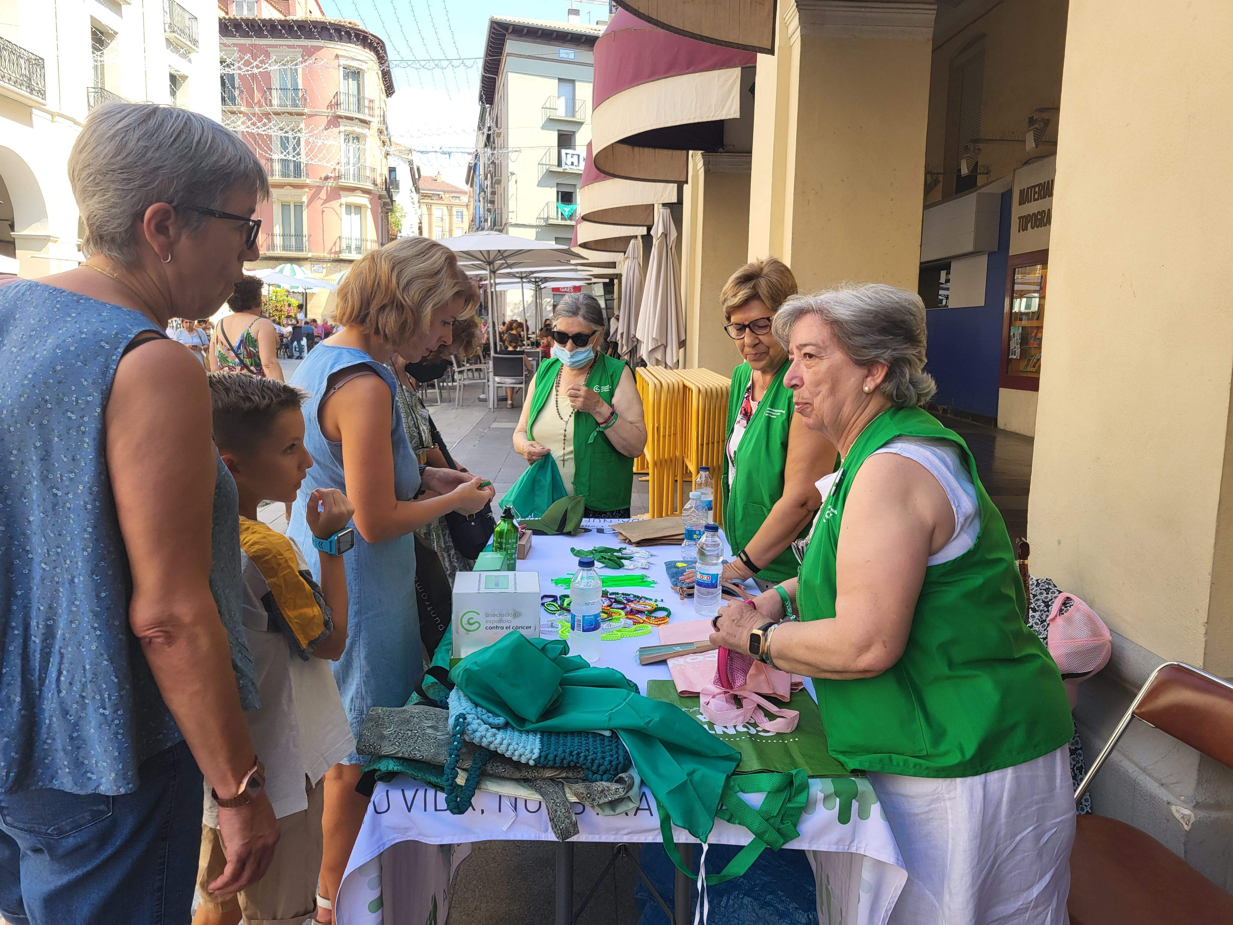 Voluntarias de la Asociación Española contra el Cáncer de Huesca venden pañoletas para San Lorenzo