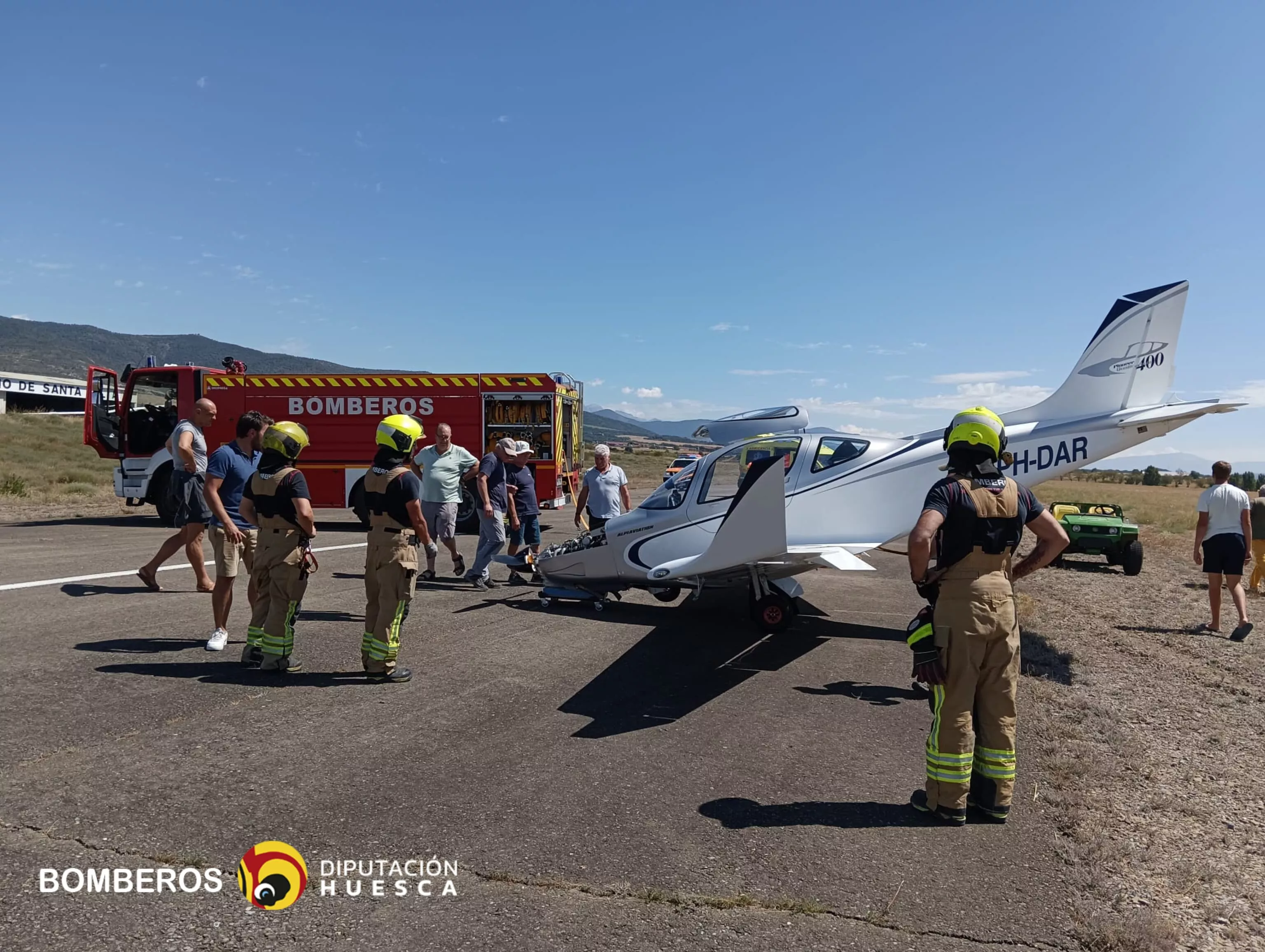 Avioneta tras el aterrizaje con bomberos que han auxiliado como prevención.